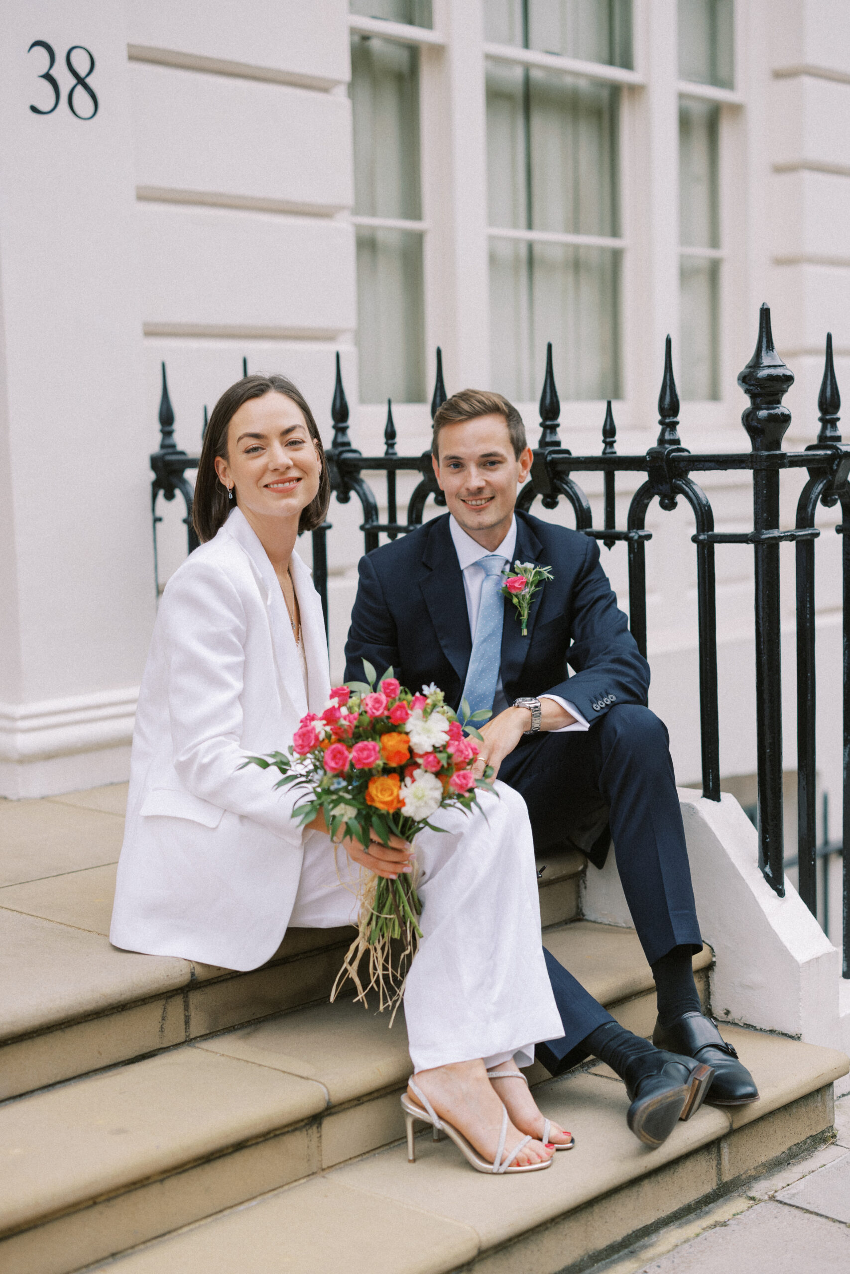 Couple sit on the steps in Chelsea at their Chelsea Old Town Hall Wedding