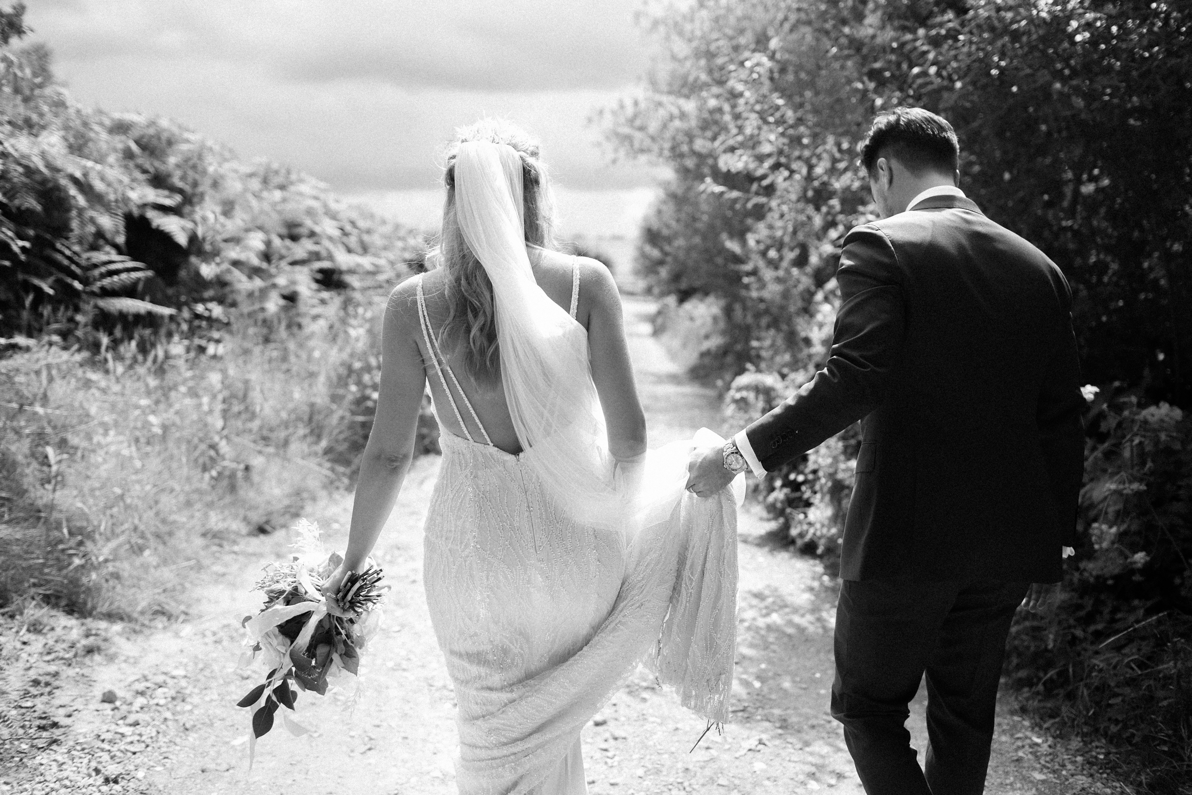 Candid wedding photography of bride and groom walking through the woods at their festival themed wedding at The Wilderness in Kent