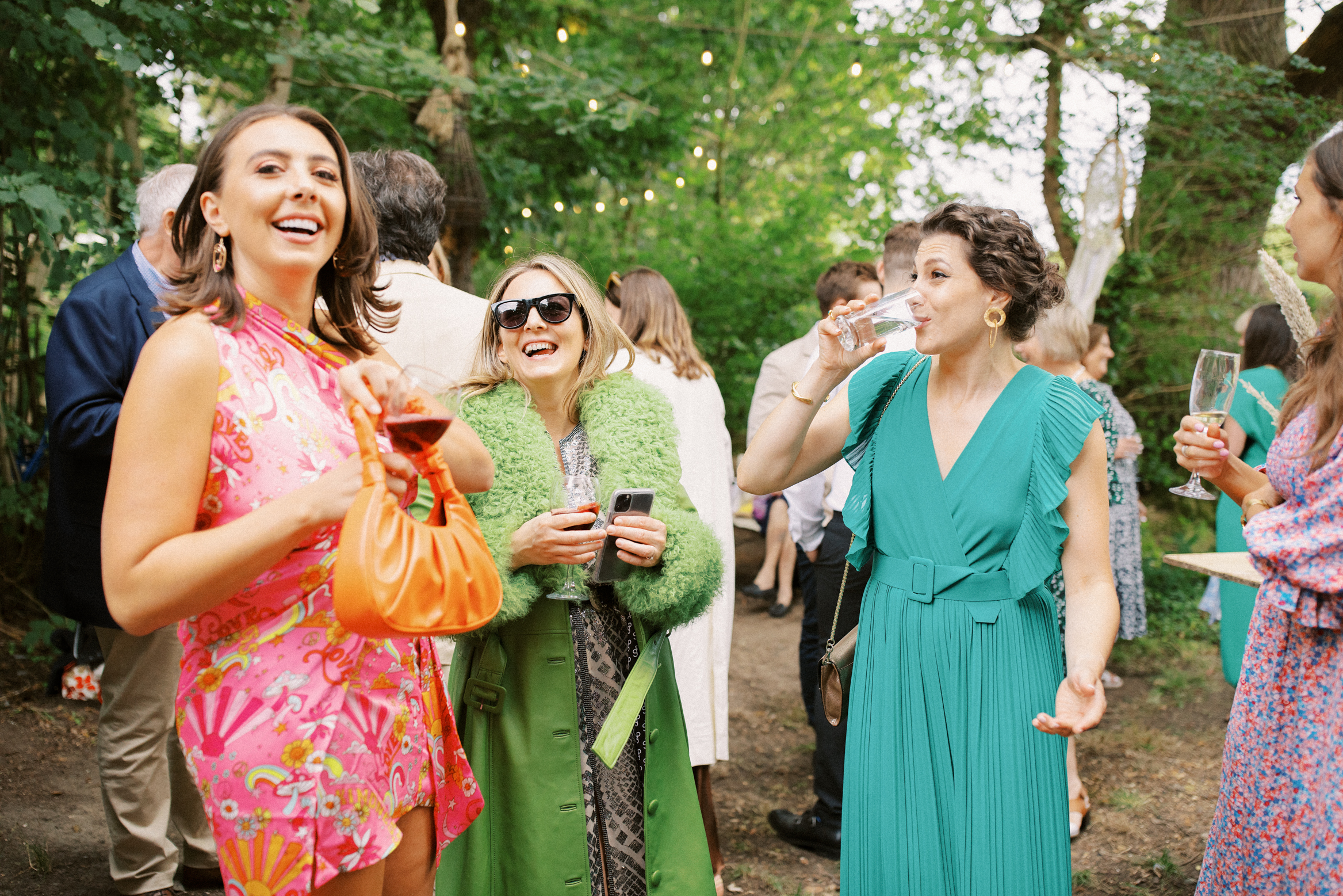 Guests laugh and smile at festival themed Wilderness Wedding in Kent