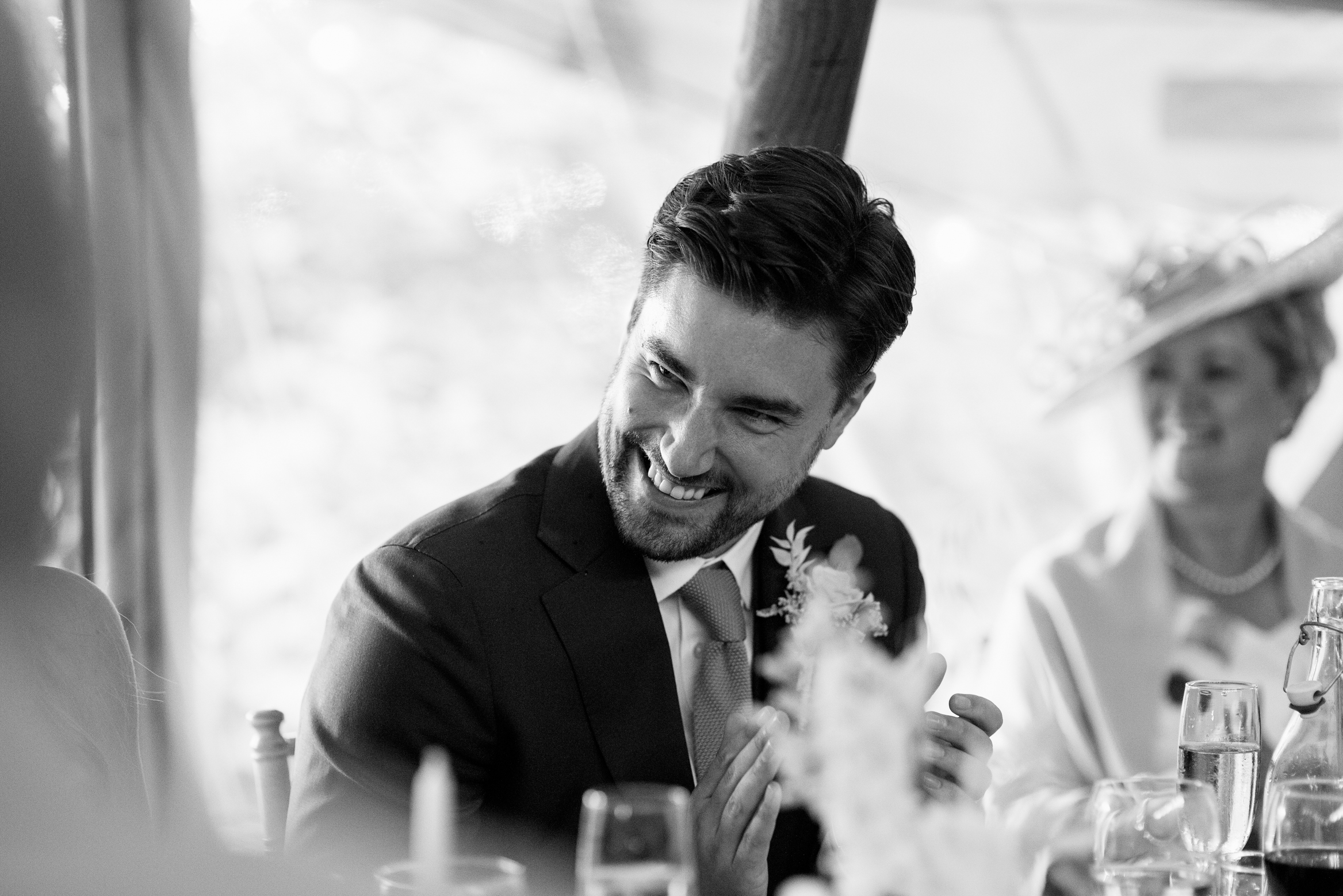 Groom laughs during the speeches at festival themed wedding