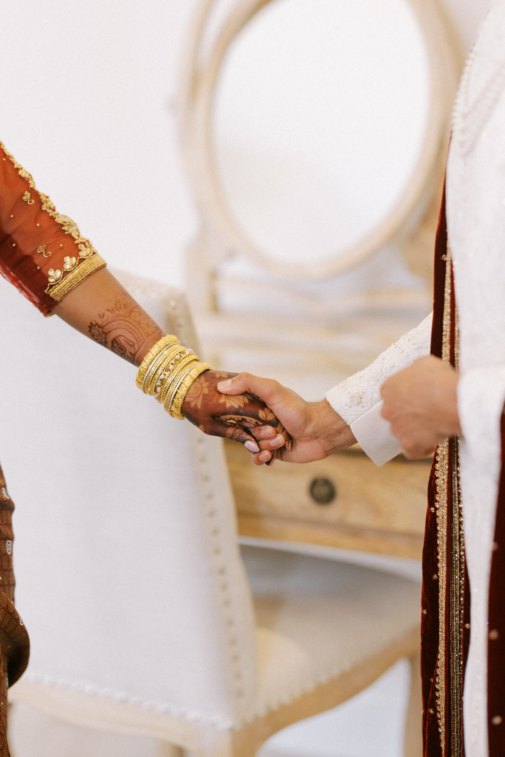 Indian bride and groom hold hands