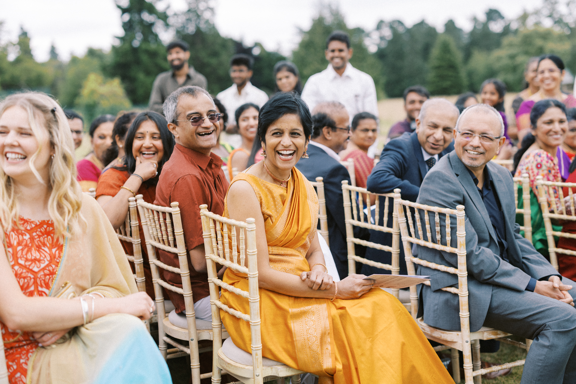 Guests smile during an Indian wedding ceremony at Hedsor House