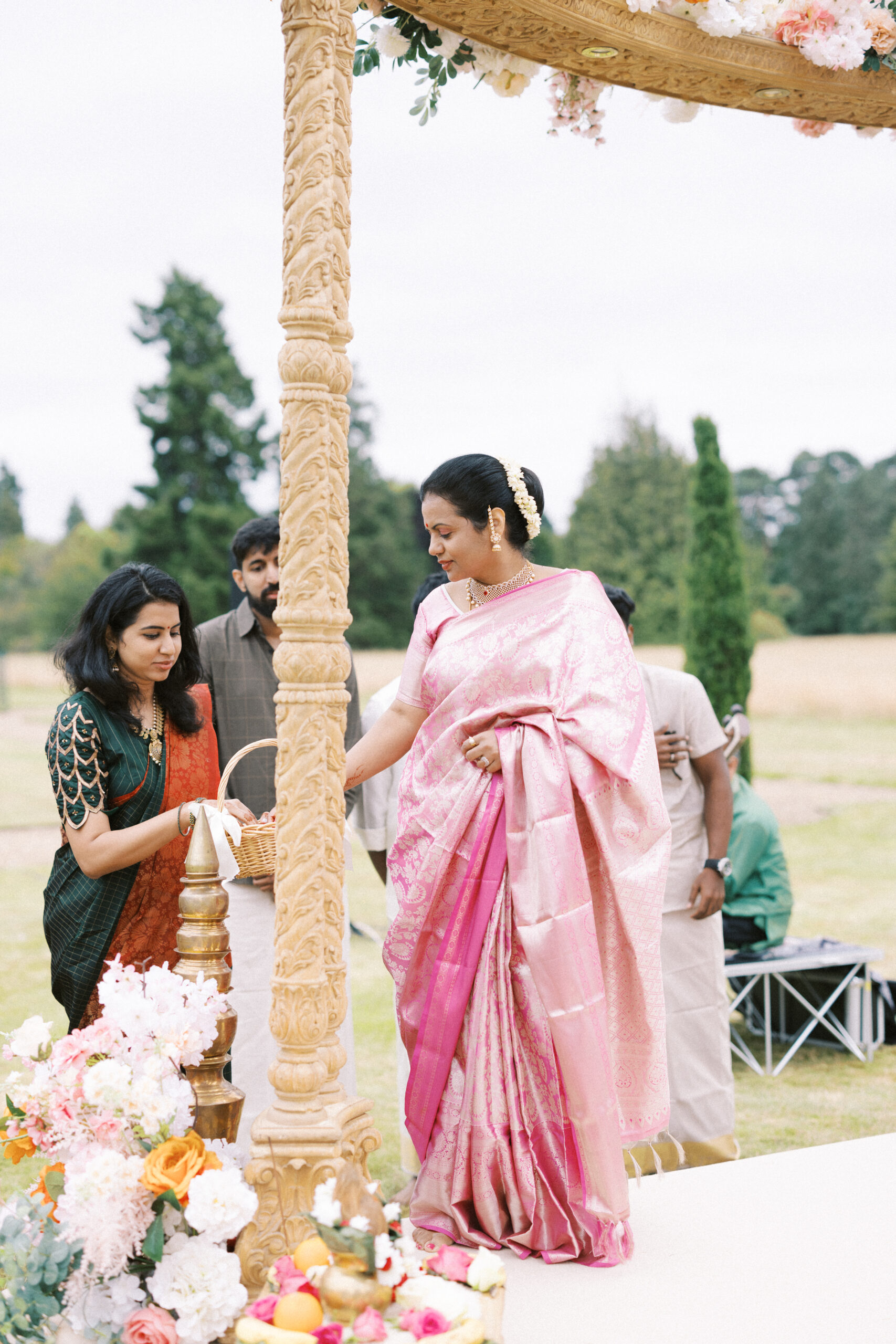 Brides mum picks up some flowers during Indian wedding service