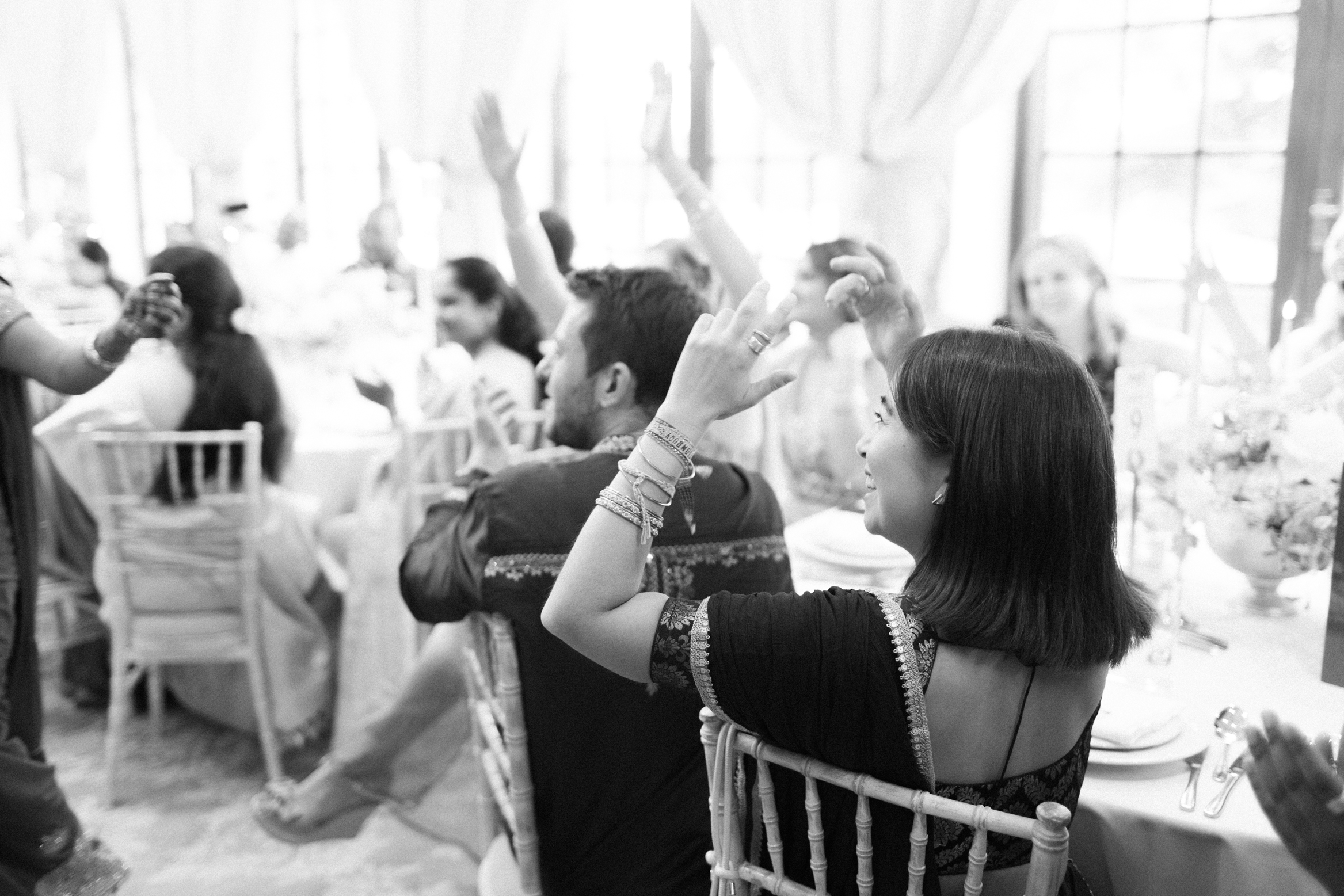 Guests cheers as bride and groom enter their wedding breakfast