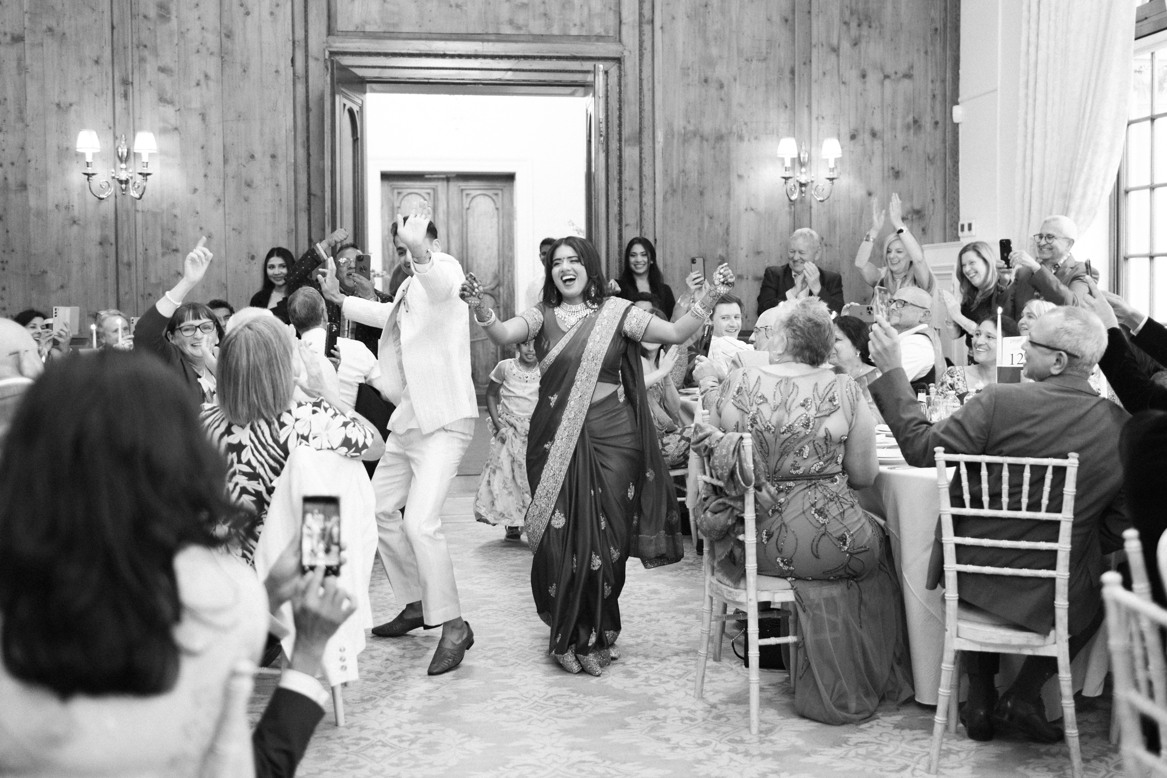 Documentary wedding photography by Gemma Vaughan Photography of indian couple entering their wedding reception at Hedsor House