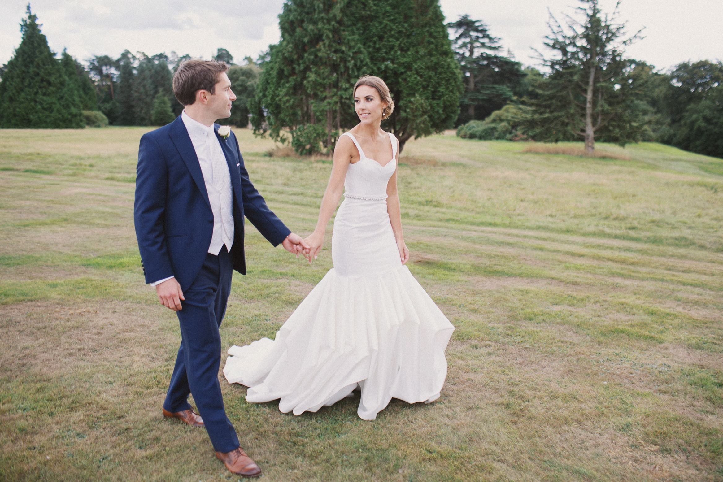 Couple walk in the ground at Hedsor House on their wedding day