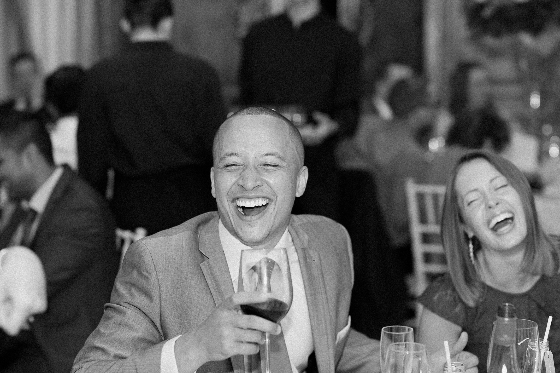 Guests laugh during the speeches at Hedsor House wedding