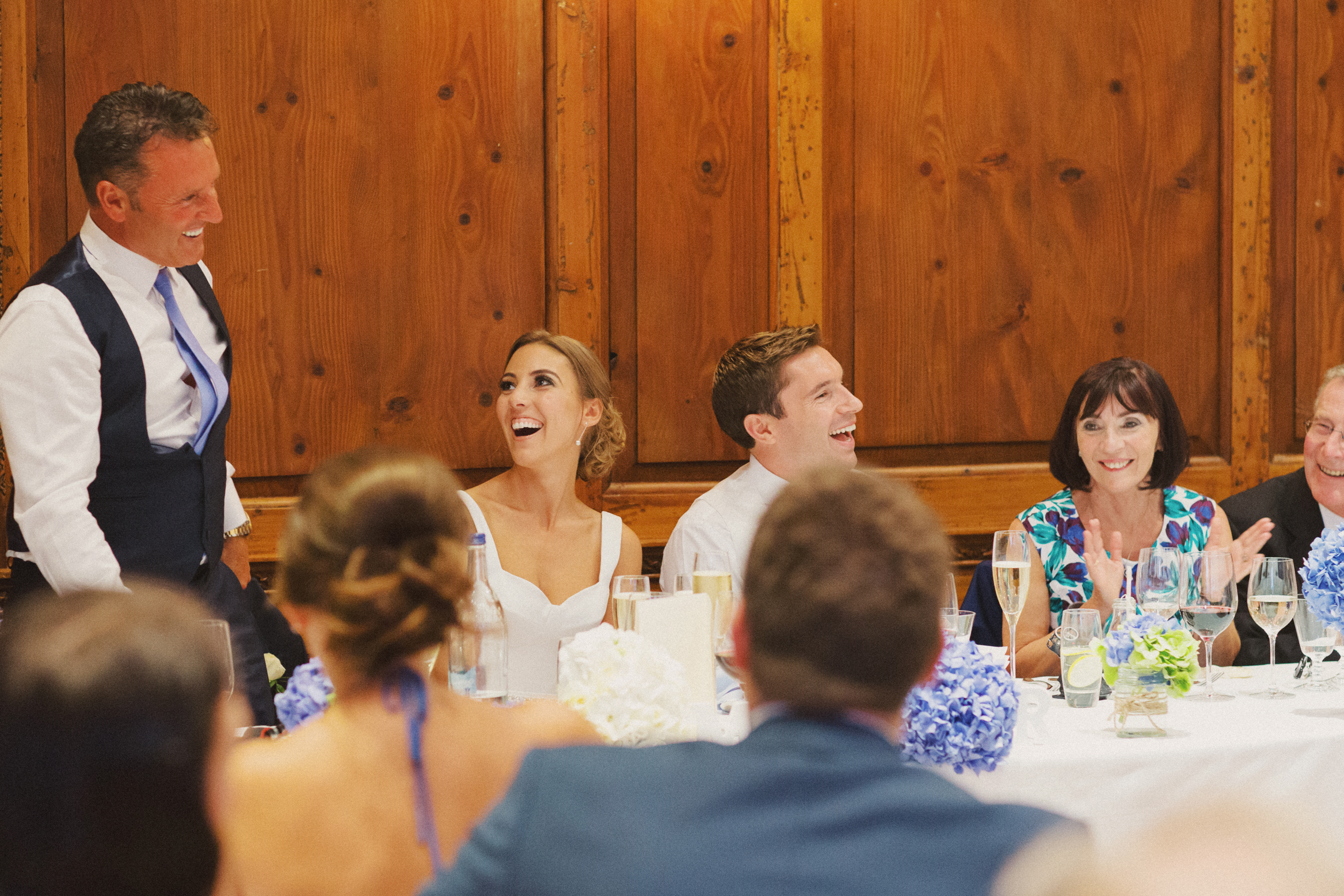 Couple laugh during the speeches on their wedding day at Hedsor House