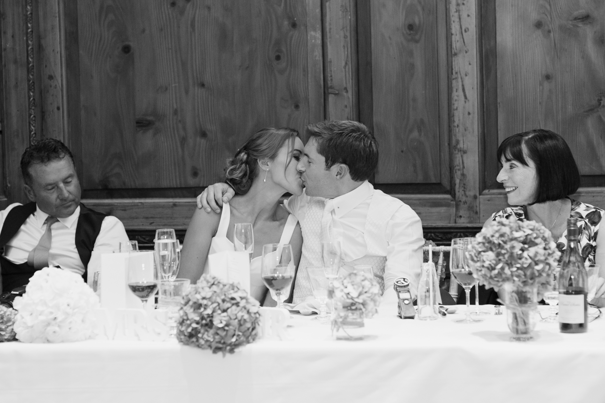 Bride and groom kiss on their wedding day during the speeches