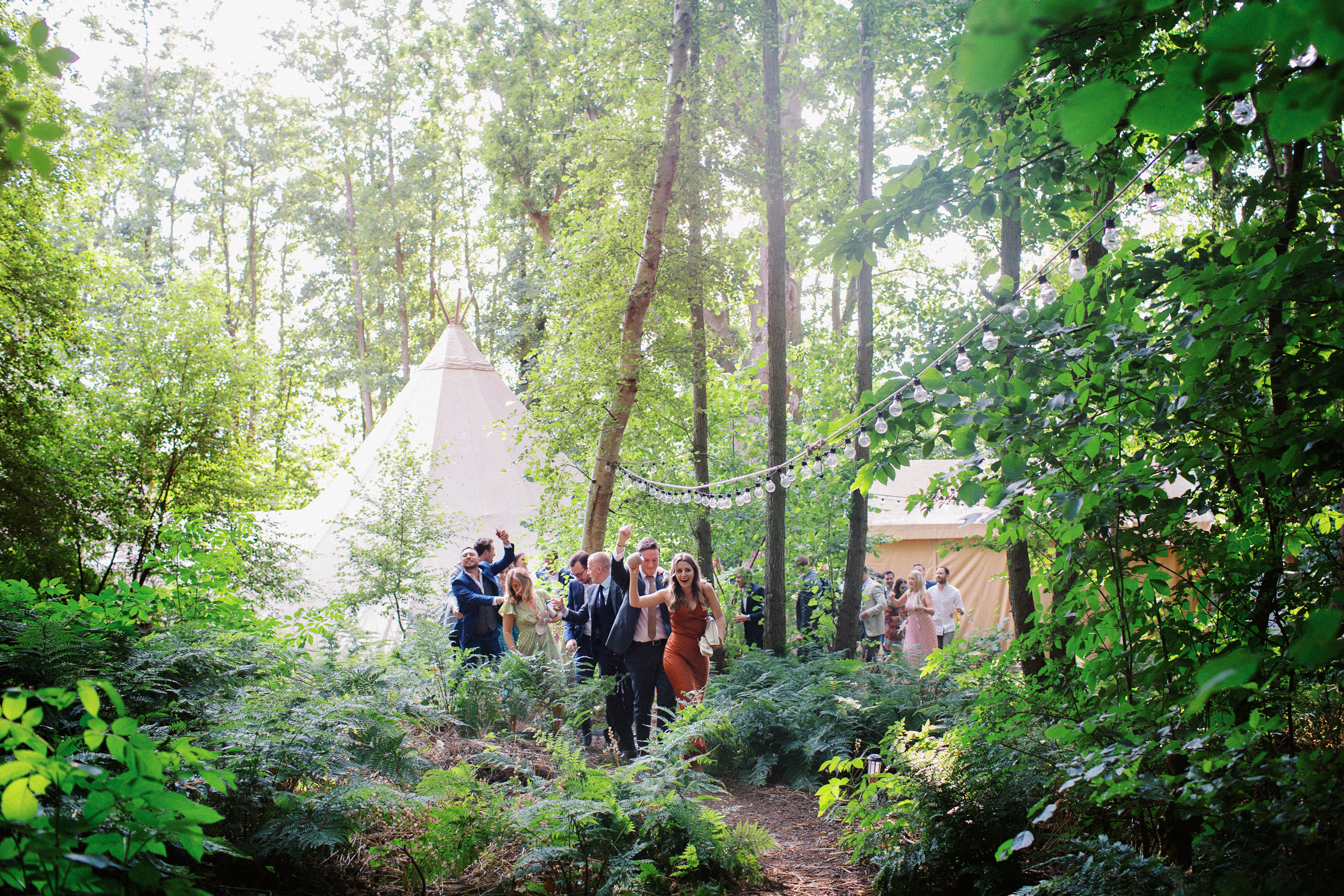 Documentary Kent Wedding Photography of guests walking through The Wilderness Reserve woods at Wilderness Wedding Venue in Kent on their way to Preston Court