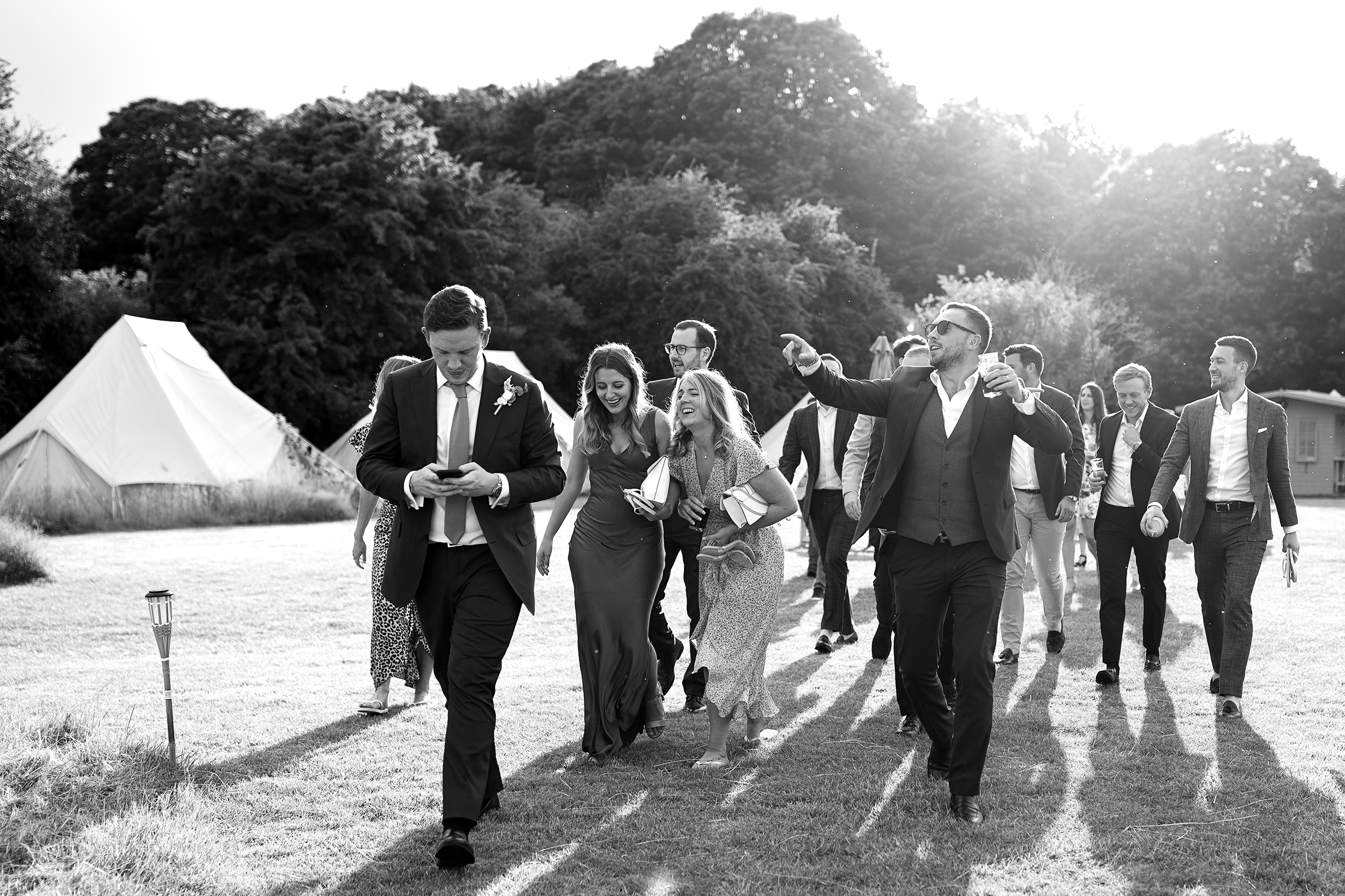 Festival themed Preston Court wedding Photography of guests cheering in the gardens at Preston Court