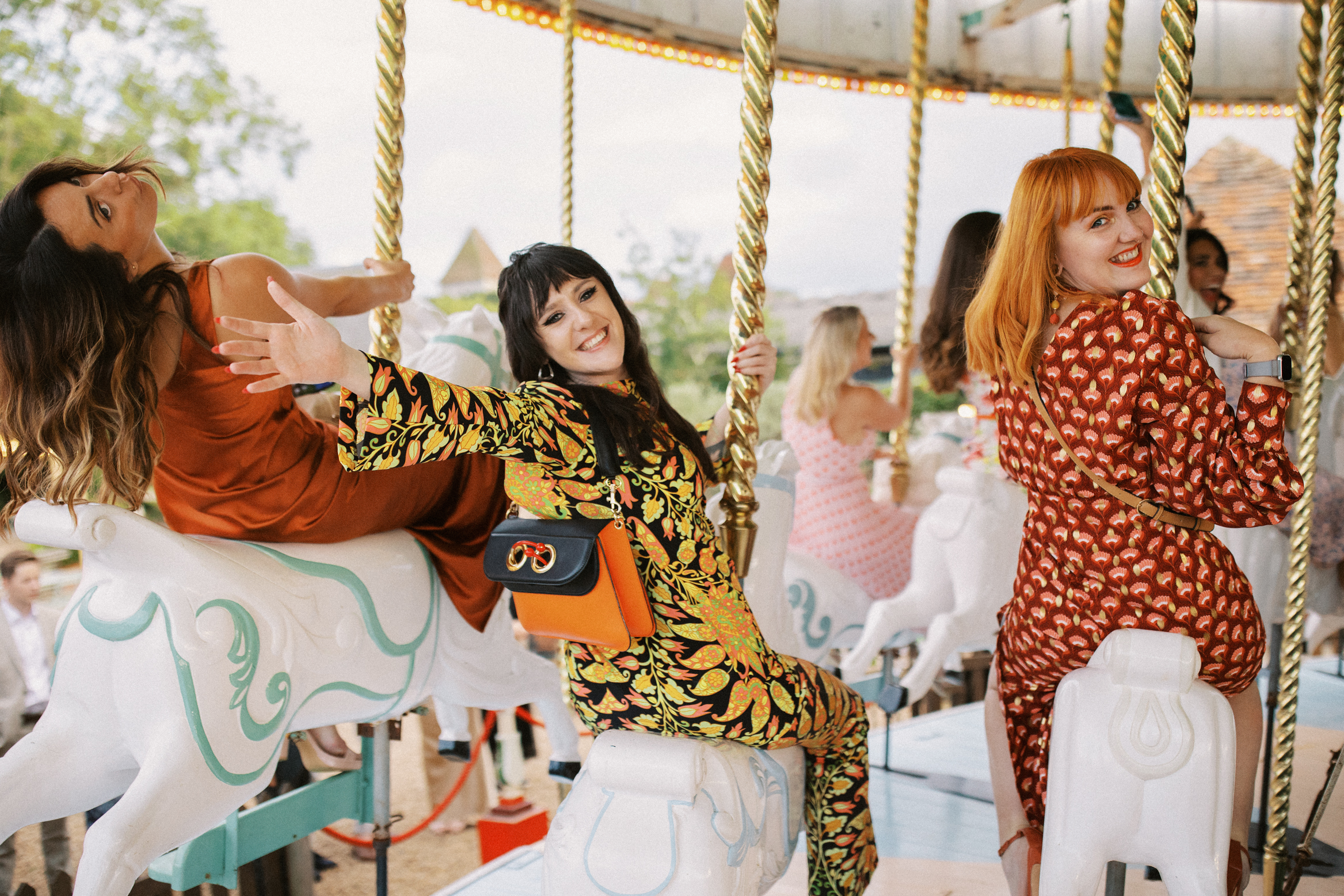 Guests ride Preston Court's Carousel at festival themed Preston Court Wedding in Kent.