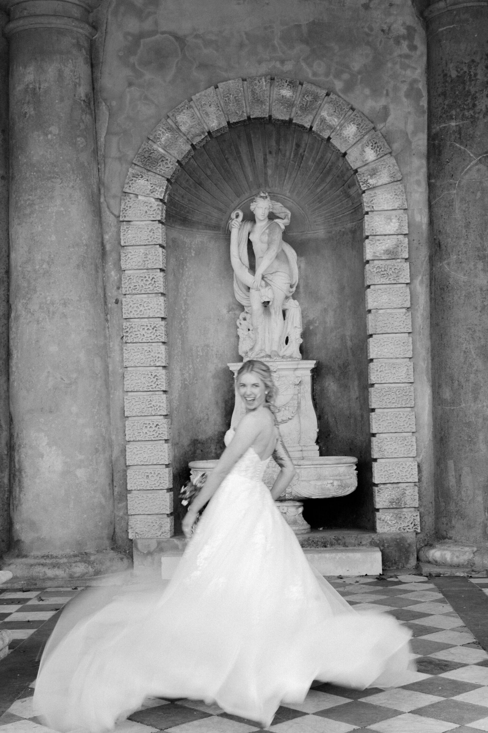 Bride laughing and spinning her dress during a Wotton House wedding photoshoot