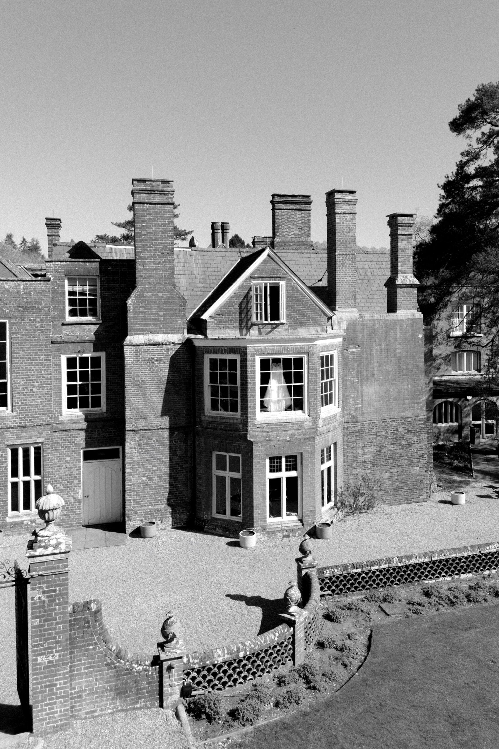 Bridal gown hanging in the window at Wotton House Wedding Venue in Surrey.