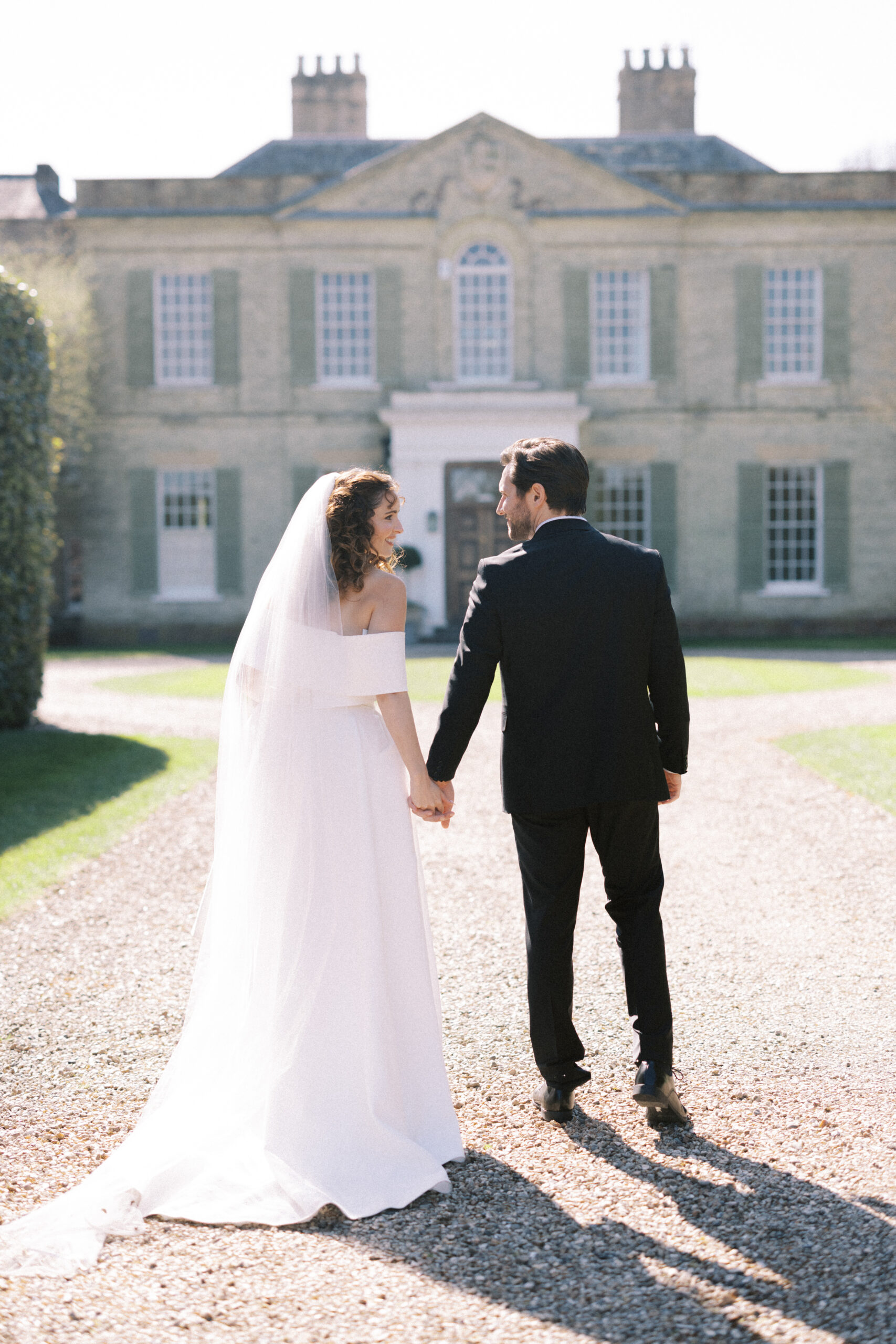 Couple walking through manicured gardens at Findon Place, captured by a Findon Place wedding photographer