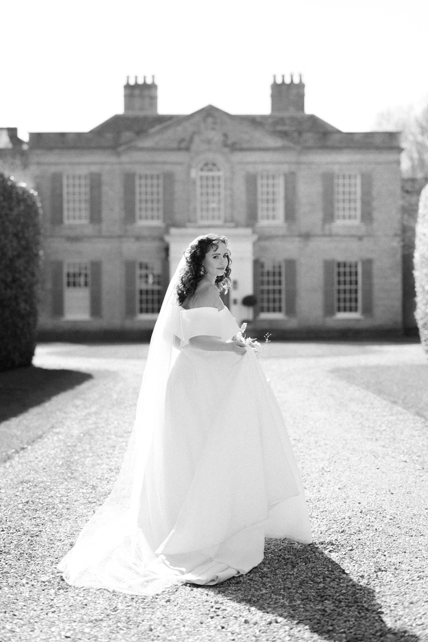 Bride enjoying the country house grounds at Findon Place in soft morning light