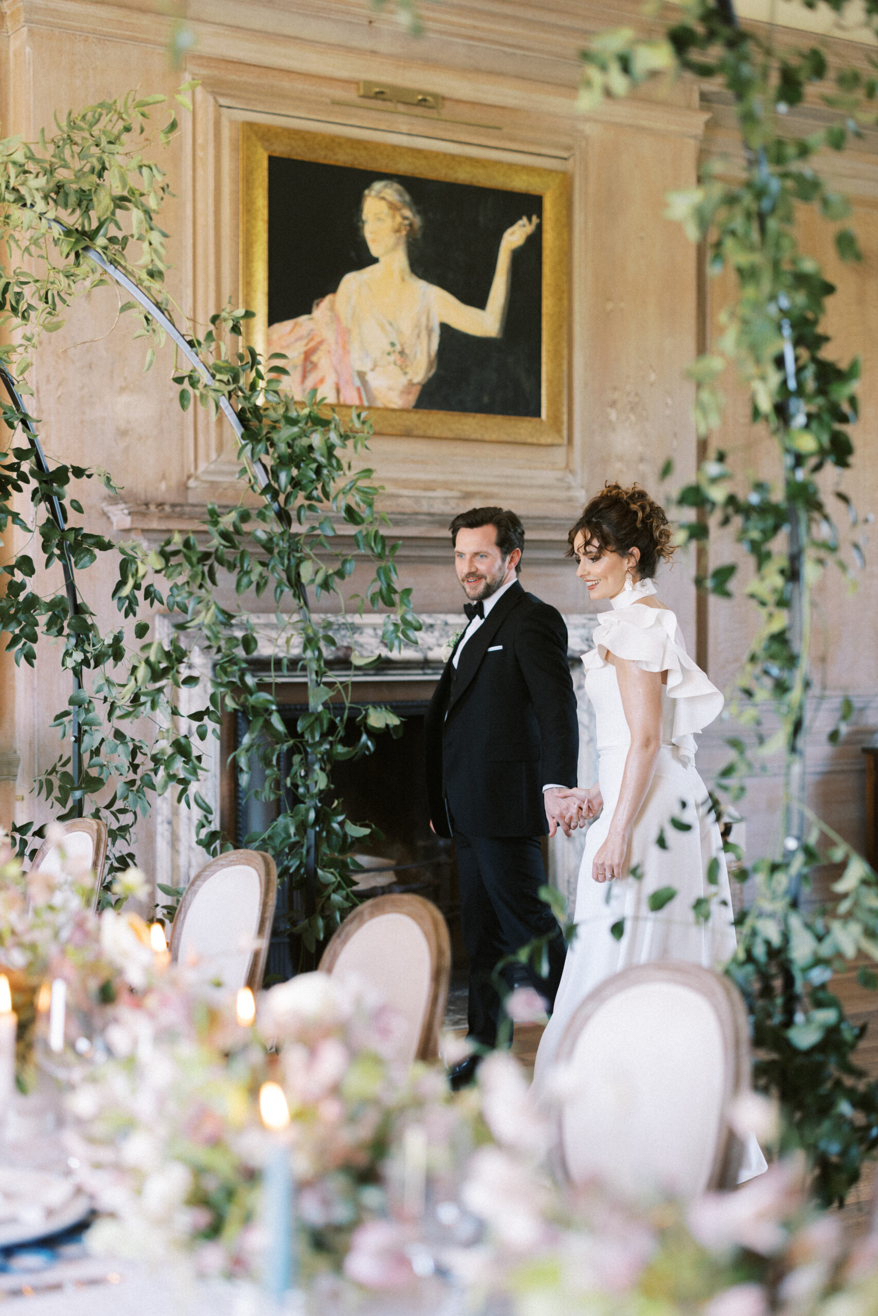 Bride and groom walk through luxury wedding table at Findon Place