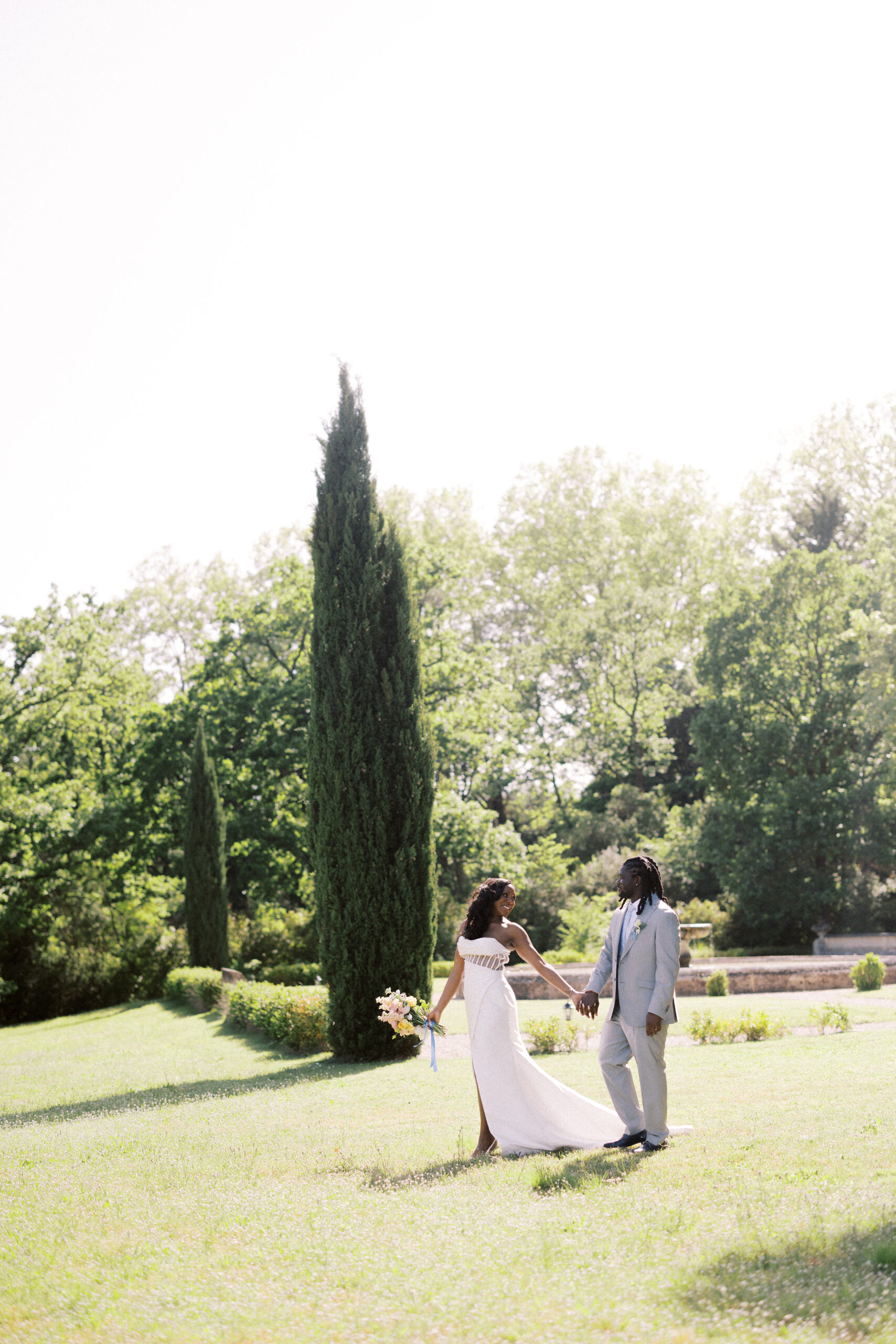 Destination wedding photography of couple walking through the grounds at Chateau de Valmousse in Provence on their wedding day.