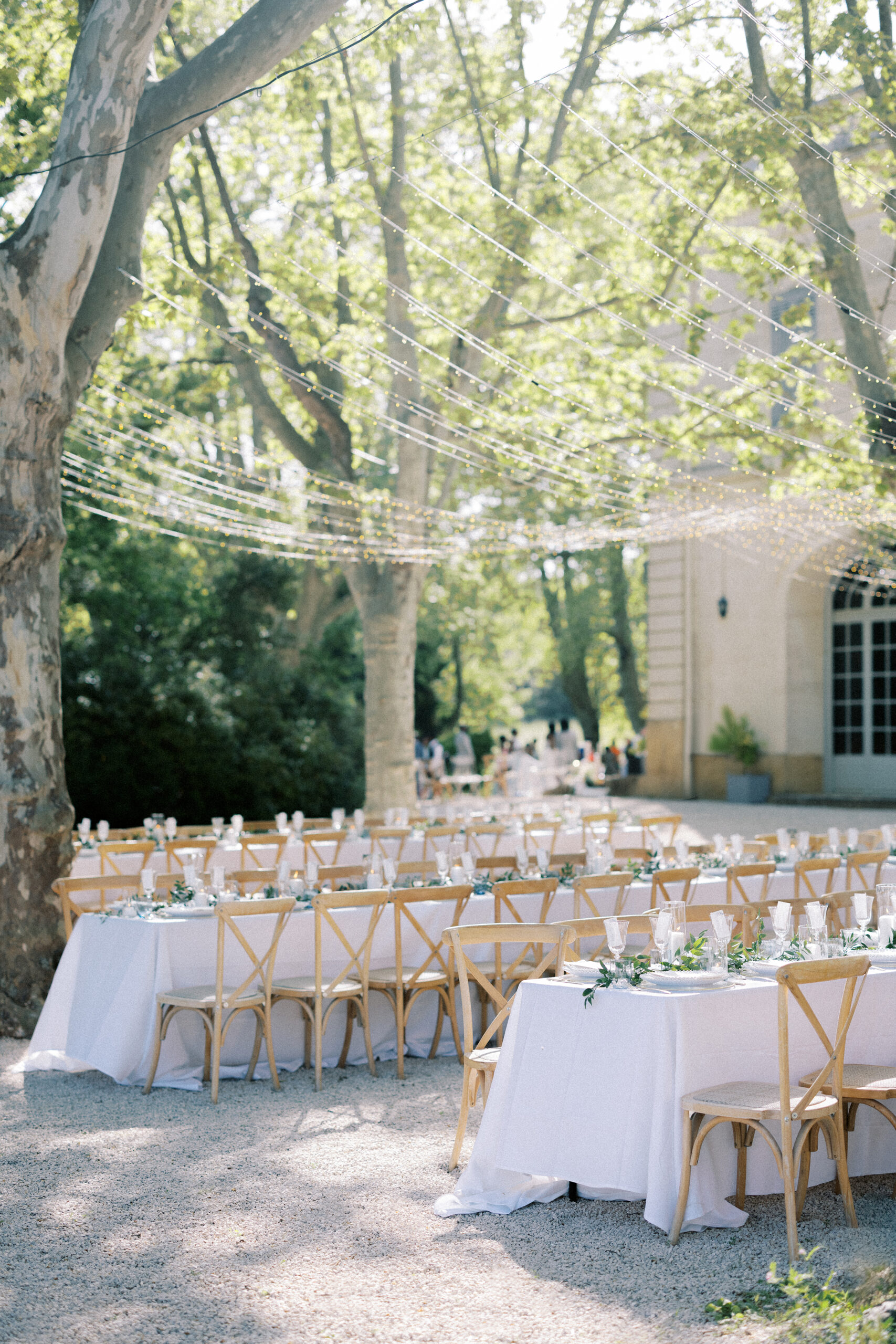 Beautiful destination wedding reception in Provence at Château de Valmousse, with long tables beneath glowing fairy lights.