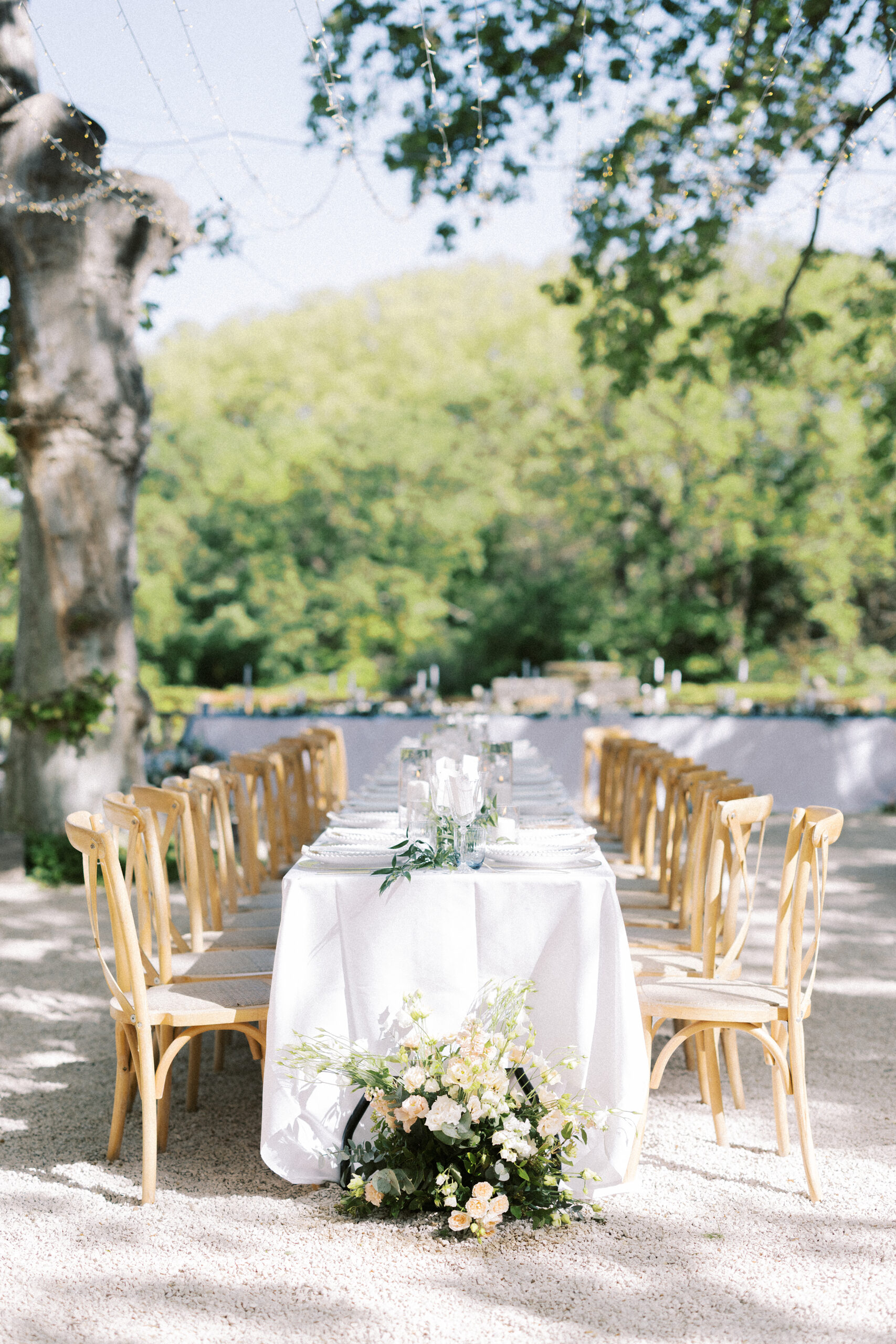 Outdoor wedding reception at Château de Valmousse, Provence, featuring long dining tables under a canopy of fairy lights.