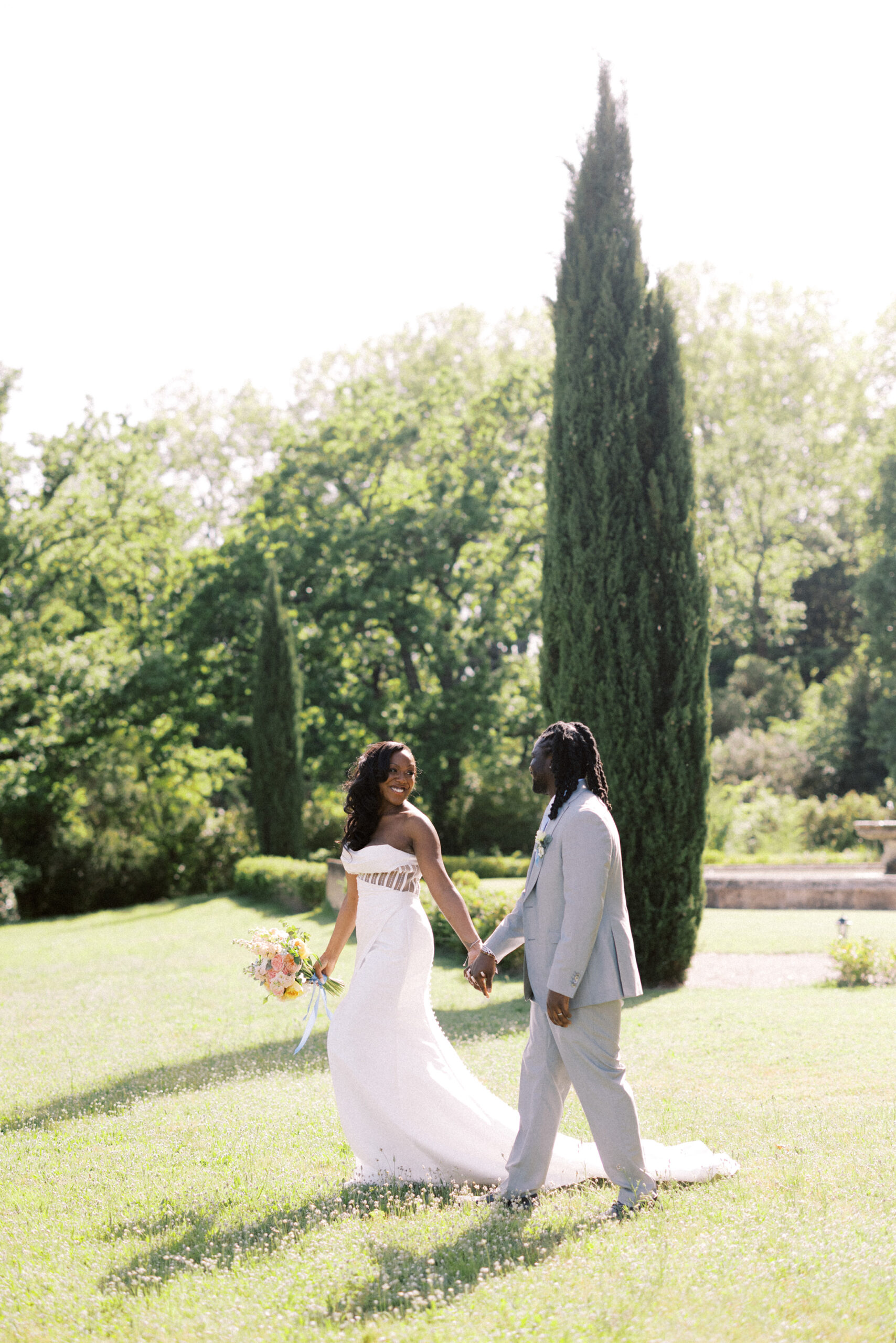 Couple walking through chateau gardens during their destination wedding in the South of France
