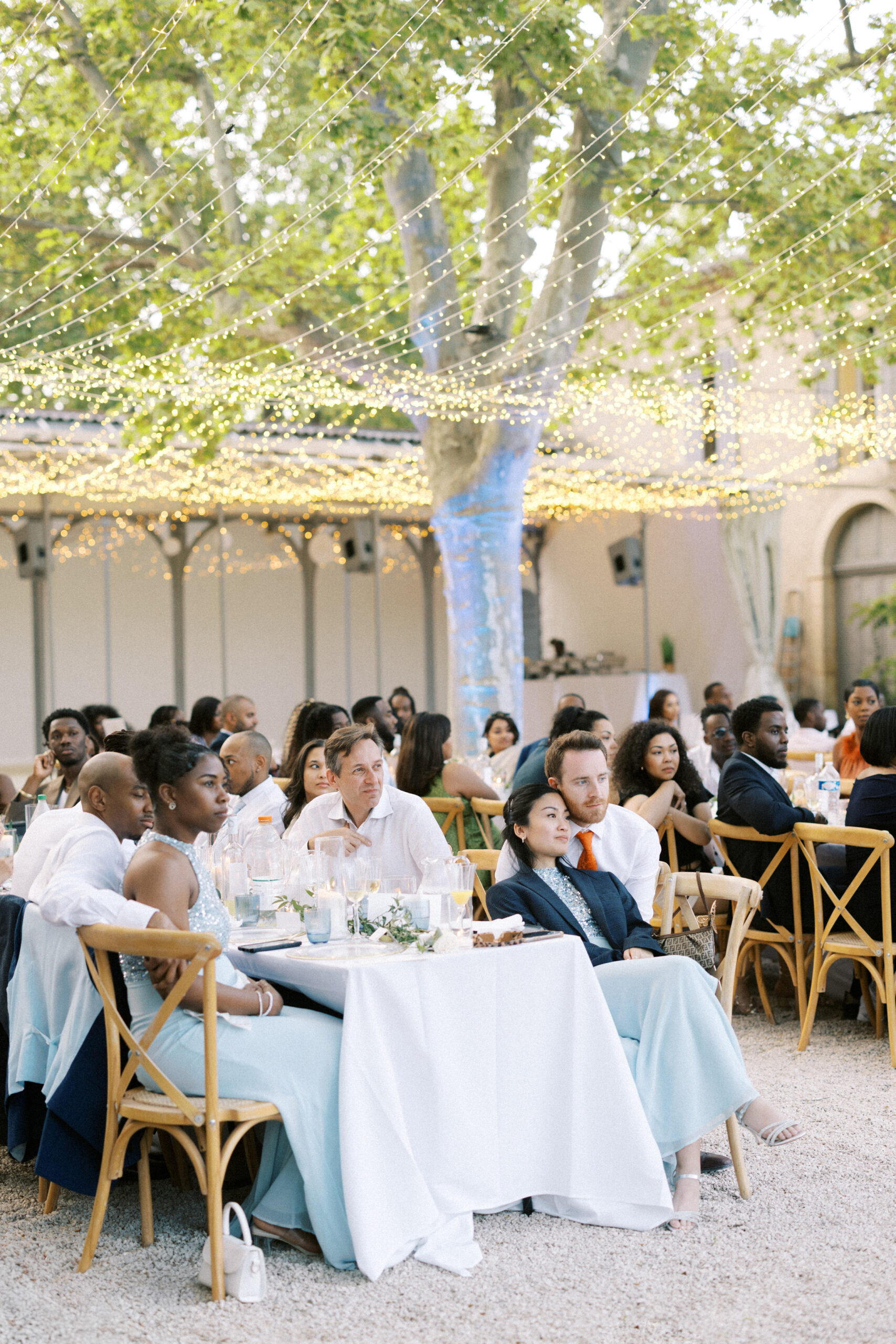 Guests listen to speeches during outside wedding breakfast at Chateau de Valmousse in France