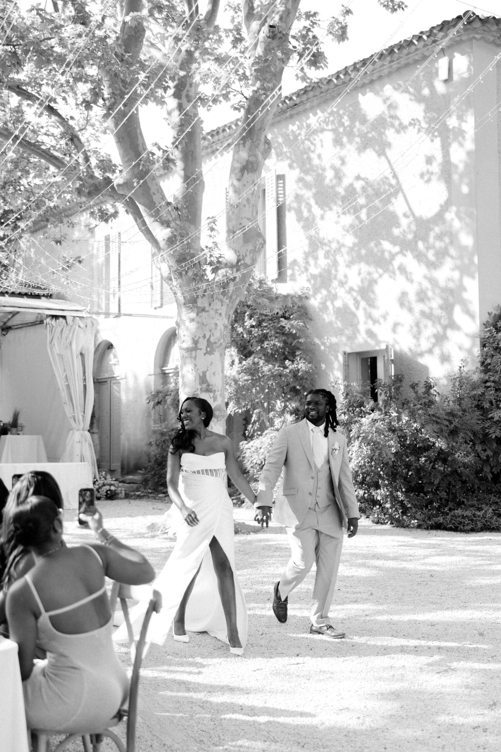 Couple arrive for their wedding breakfast outside at Chateau de Valmousse