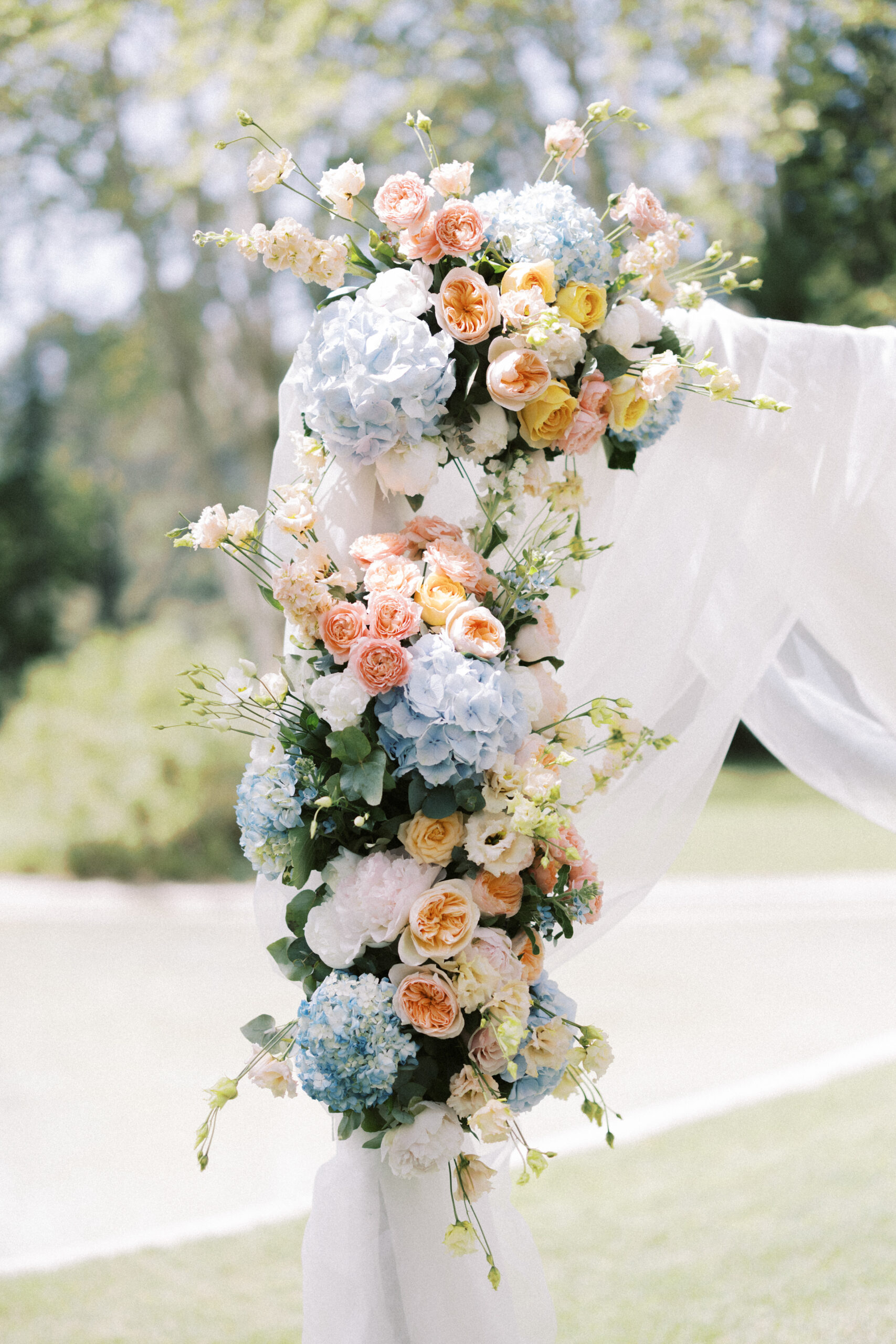 Flowers adoring a flower arch at outside wedding ceremony in France