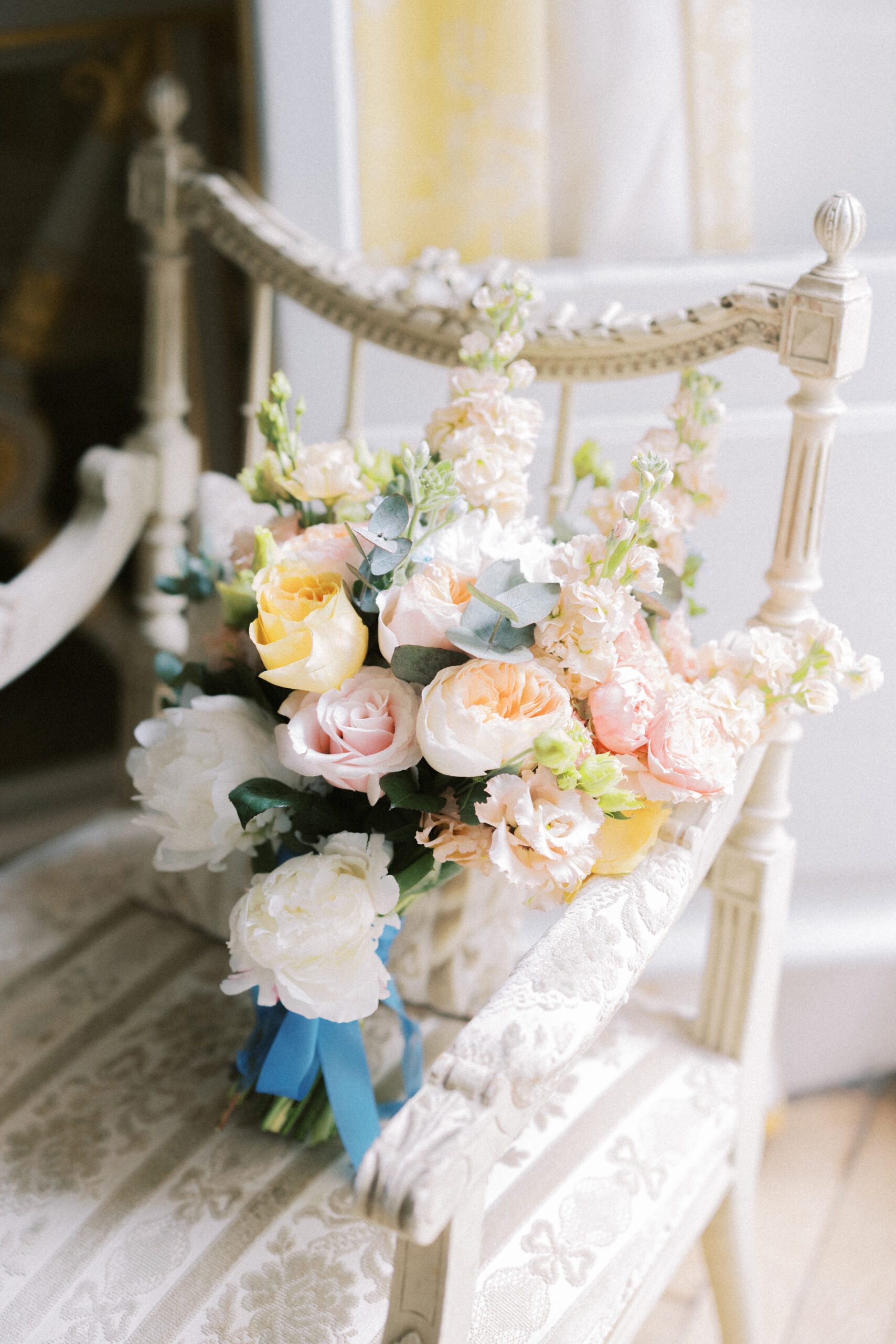 Bridal bouquet displayed on a chair at French chateau wedding