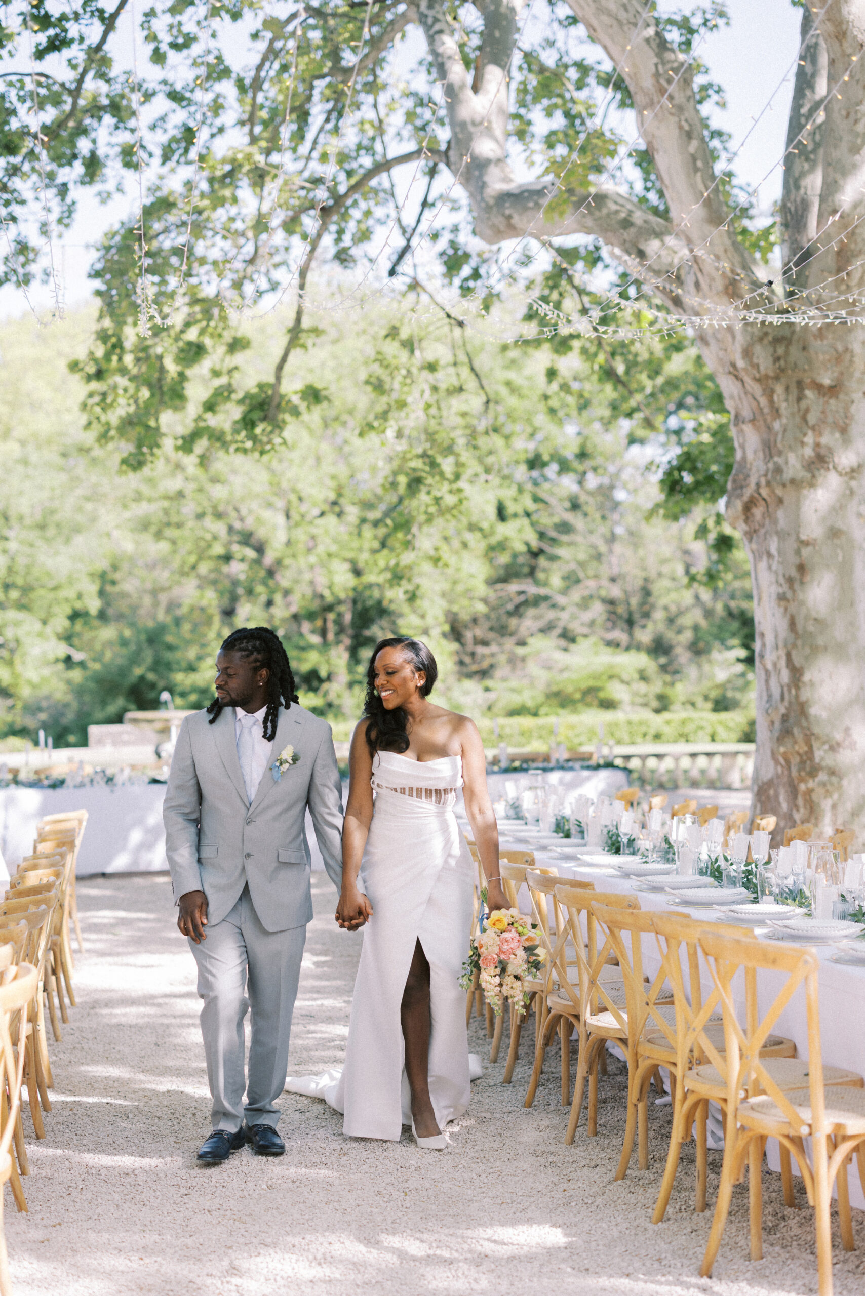 Bride and groom walk through a Luxury tablescape design with candles and florals at Chateau de Valmousse