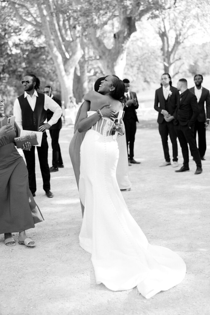 Candid wedding photograph of bride hugging her guests during drinks reception at Chateau de Valmousse wedding