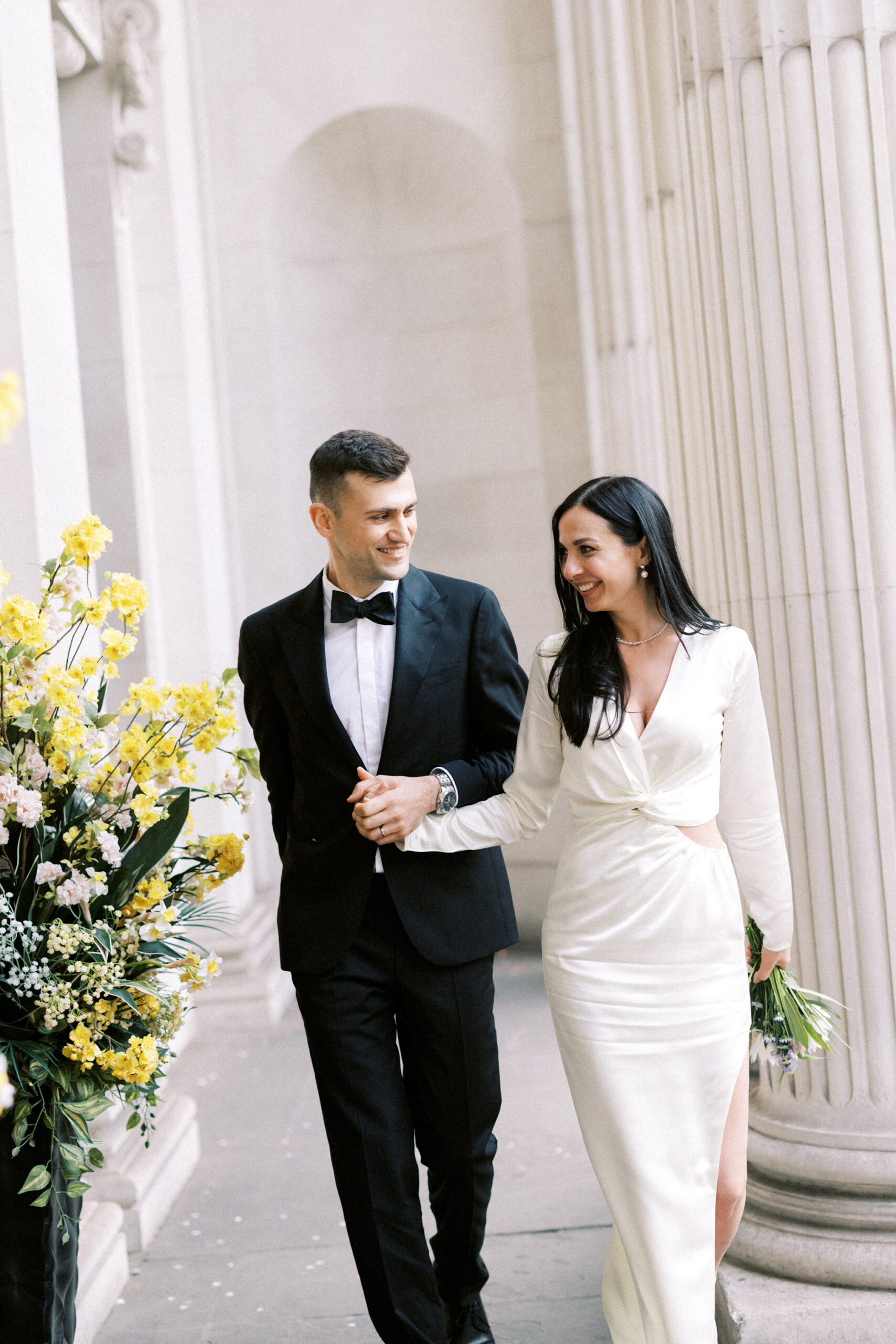 Newlywed couple walking together outside Marylebone Town Hall