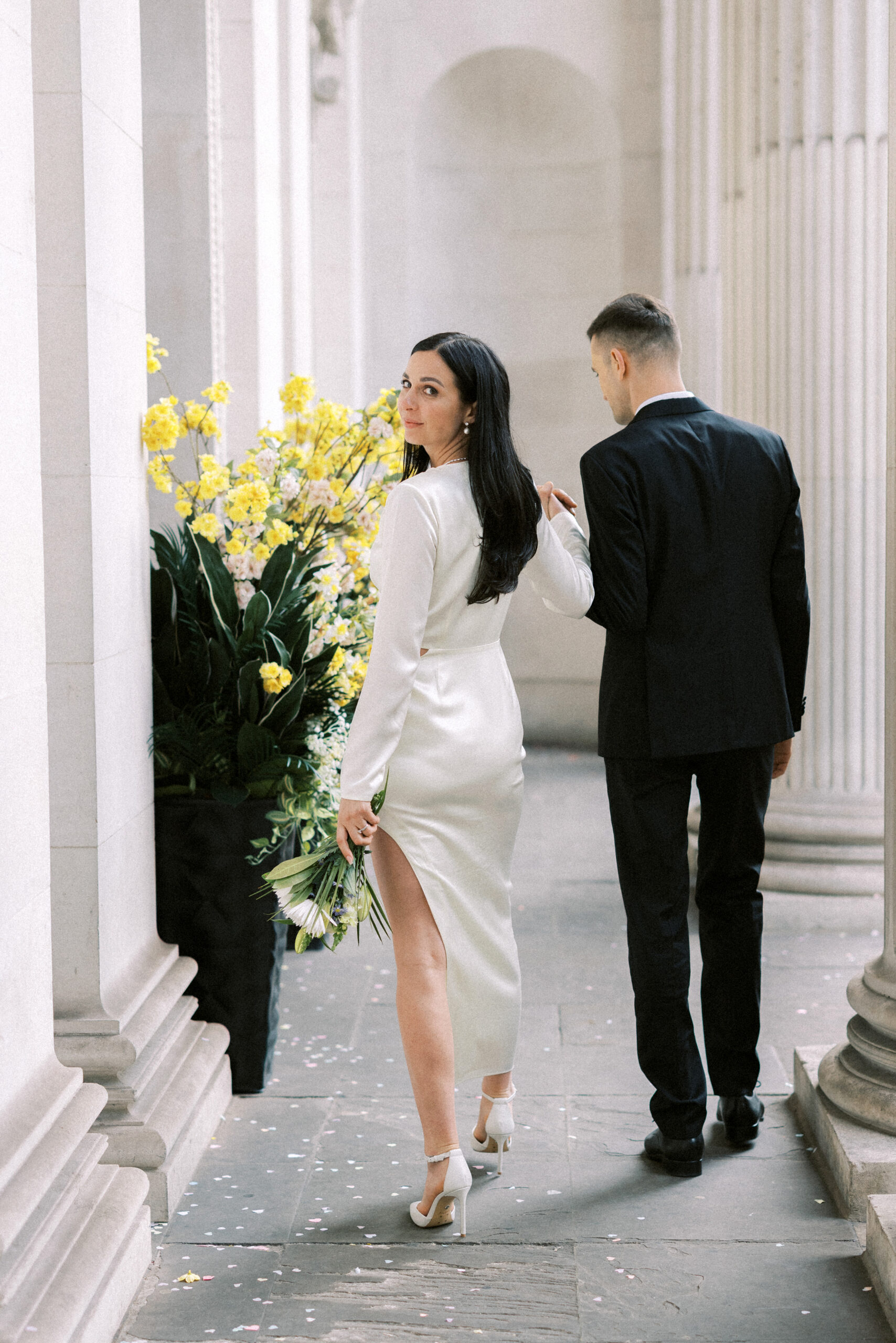 Newlywed couple walking together outside Marylebone Town Hall