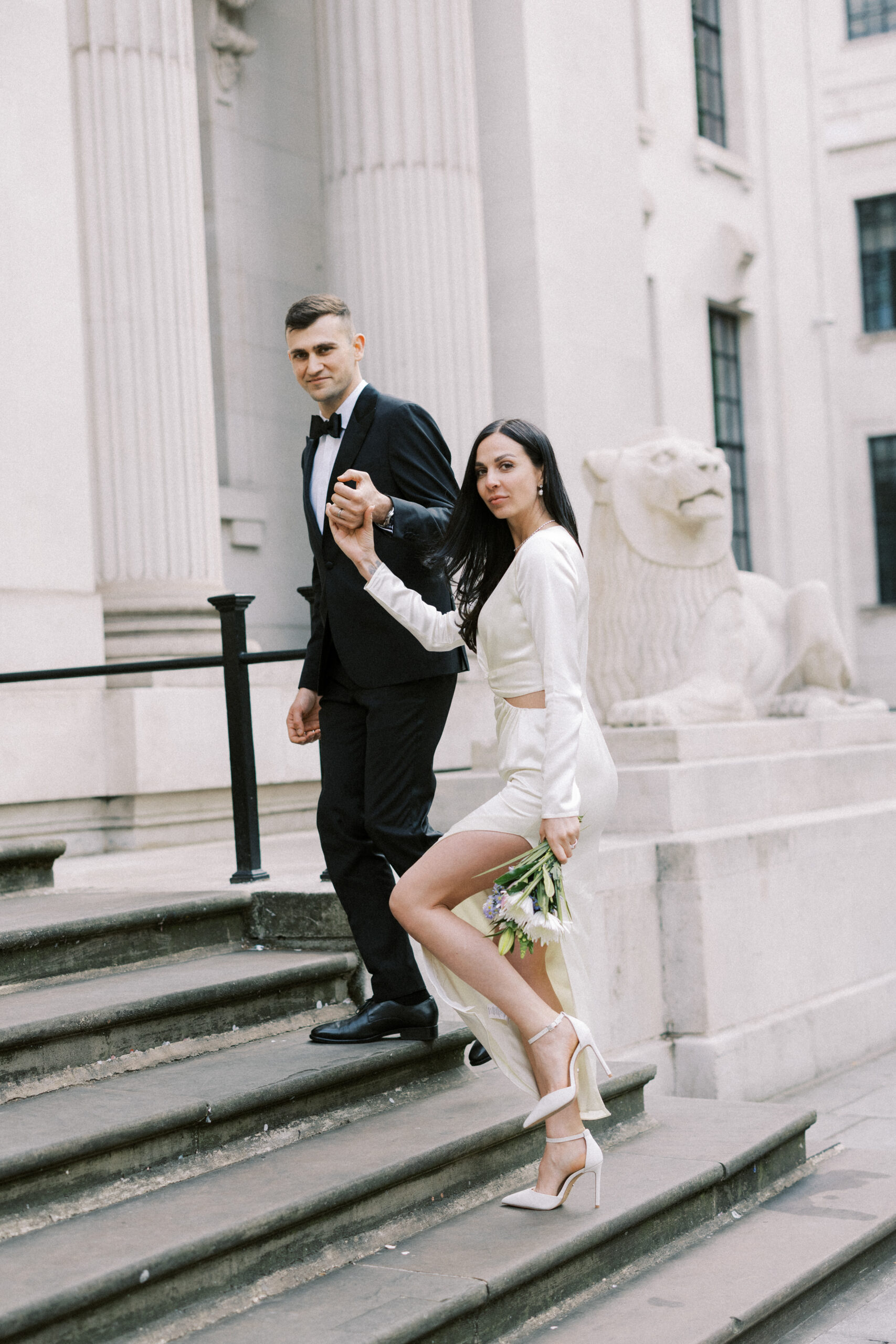 Bride & Groom walk up the steps at Marylebone Town Hall in London after just getting married