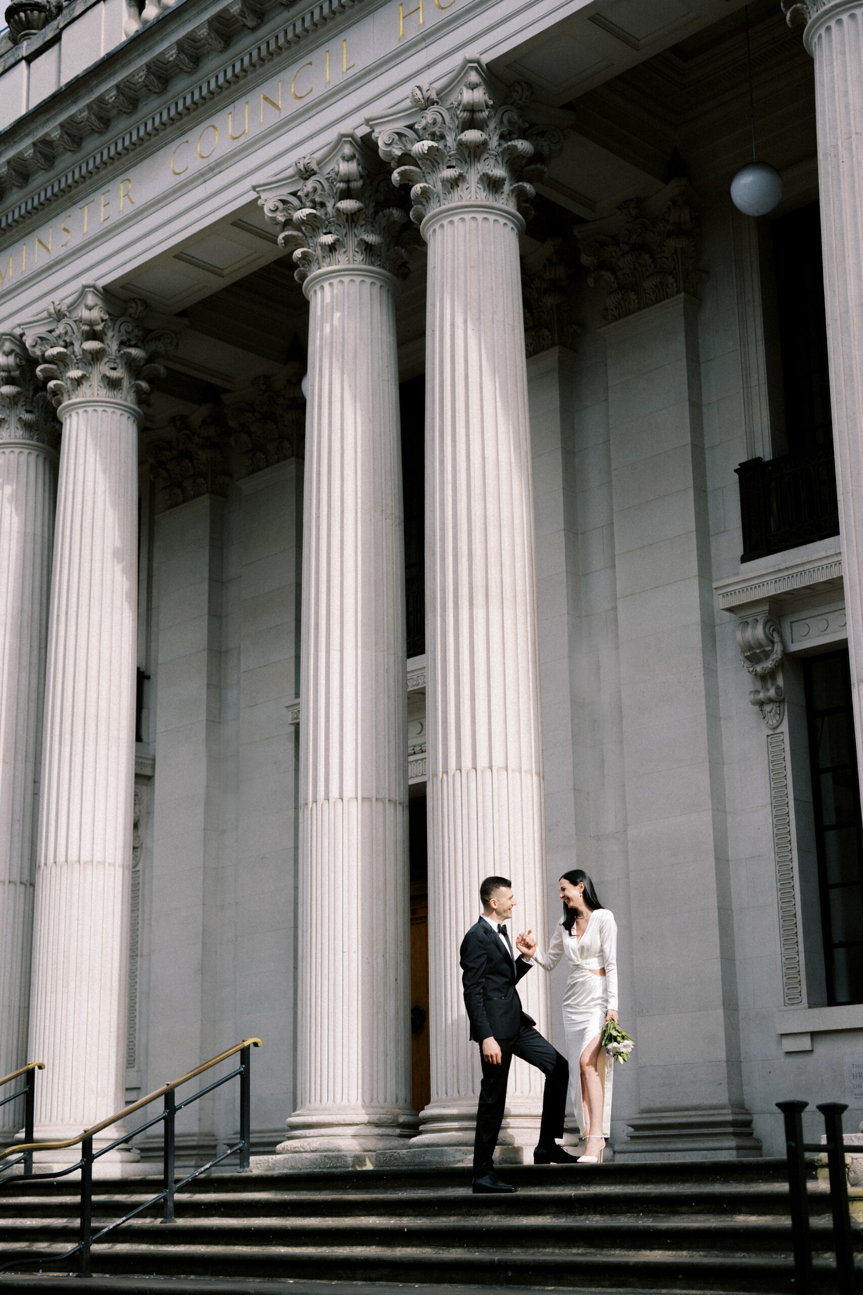 Bride & Groom laugh on the steps of Old Marylebone Town Hall in London after their intimate wedding ceremony