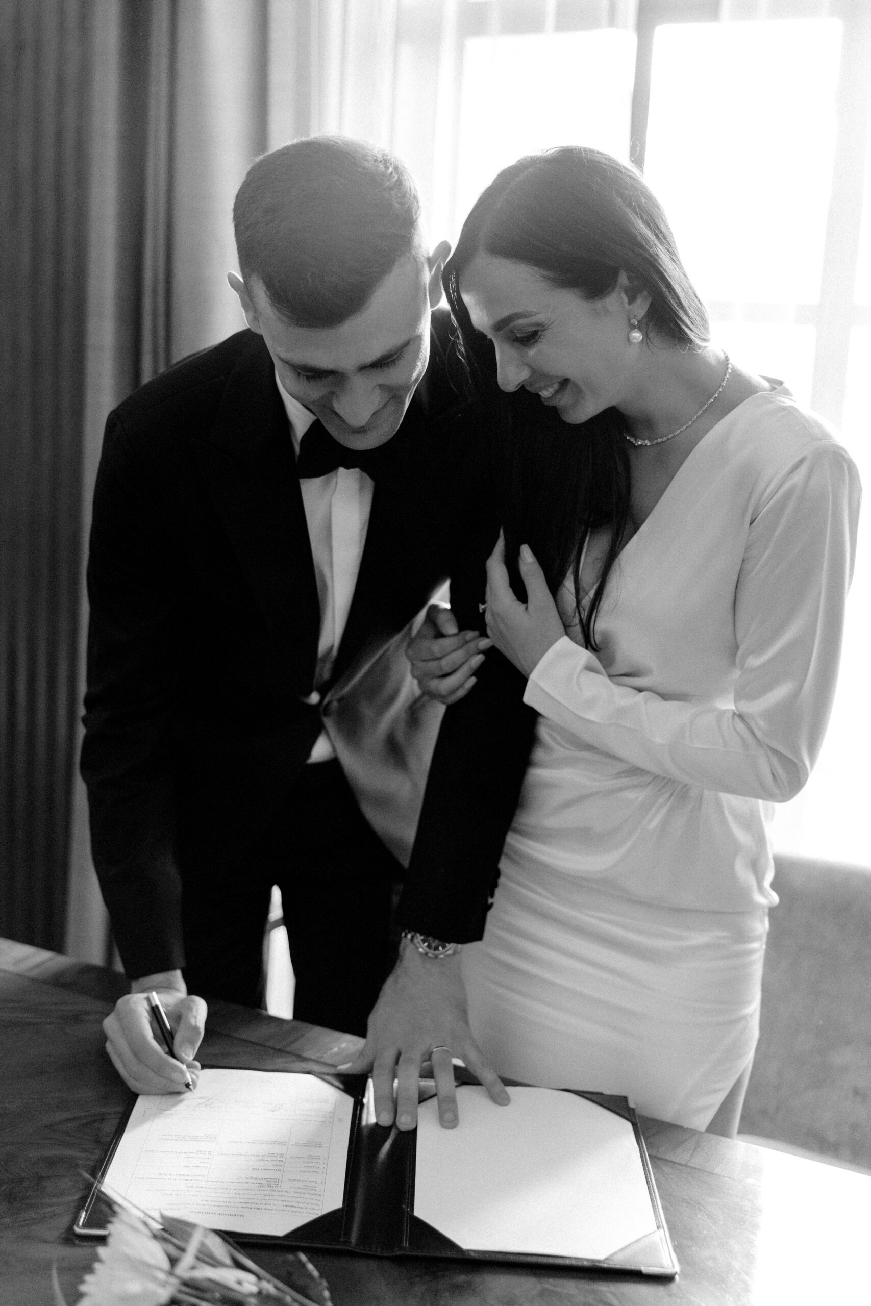 Bride and groom sign the wedding registry during their London registry office wedding