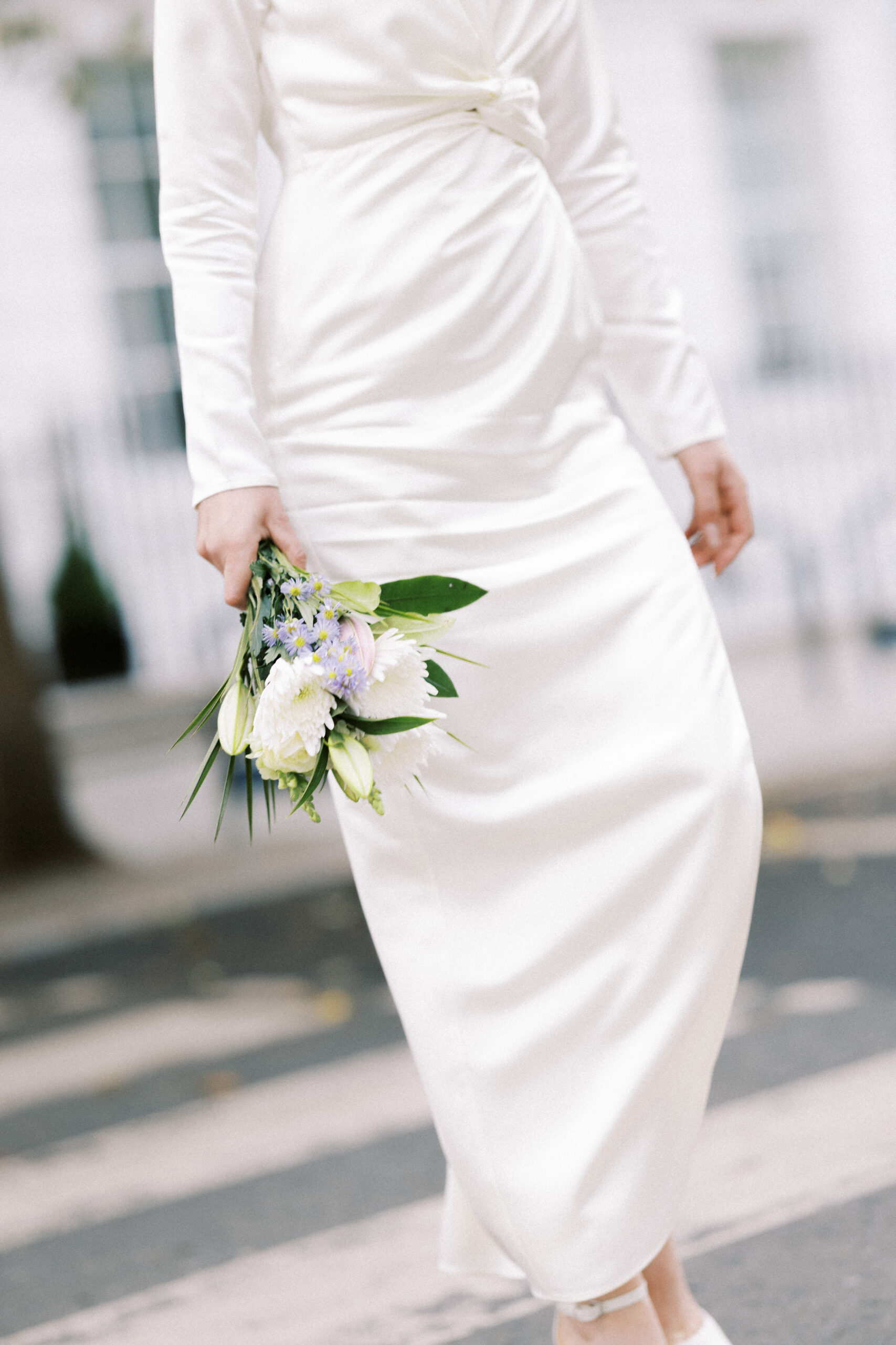 Bride holds her flowers and crosses the street after her Old Marylebone Town Hall wedding