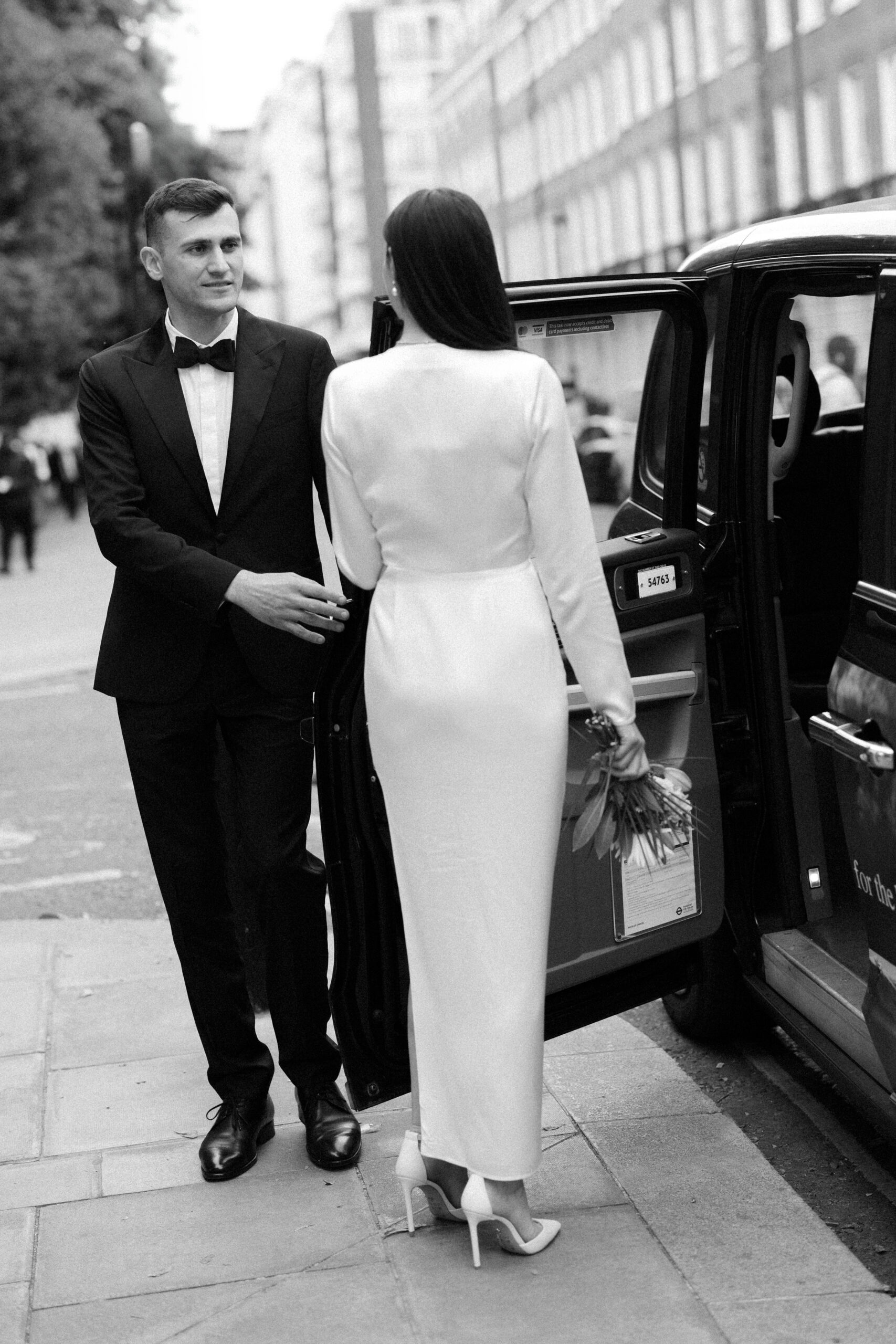 Bride & Groom get into a London black cab after their intimate wedding at Old Marylebone Town Hall in London