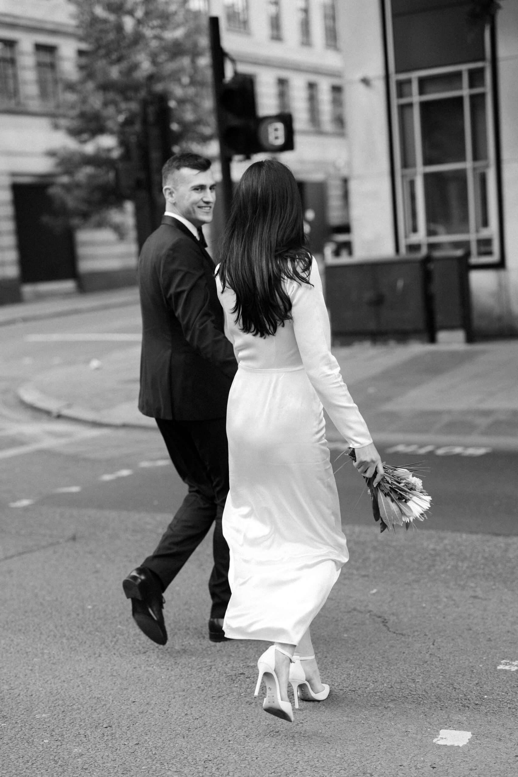 Editorial style wedding portraits of bride and groom at Marylebone Town Hall crossing the road