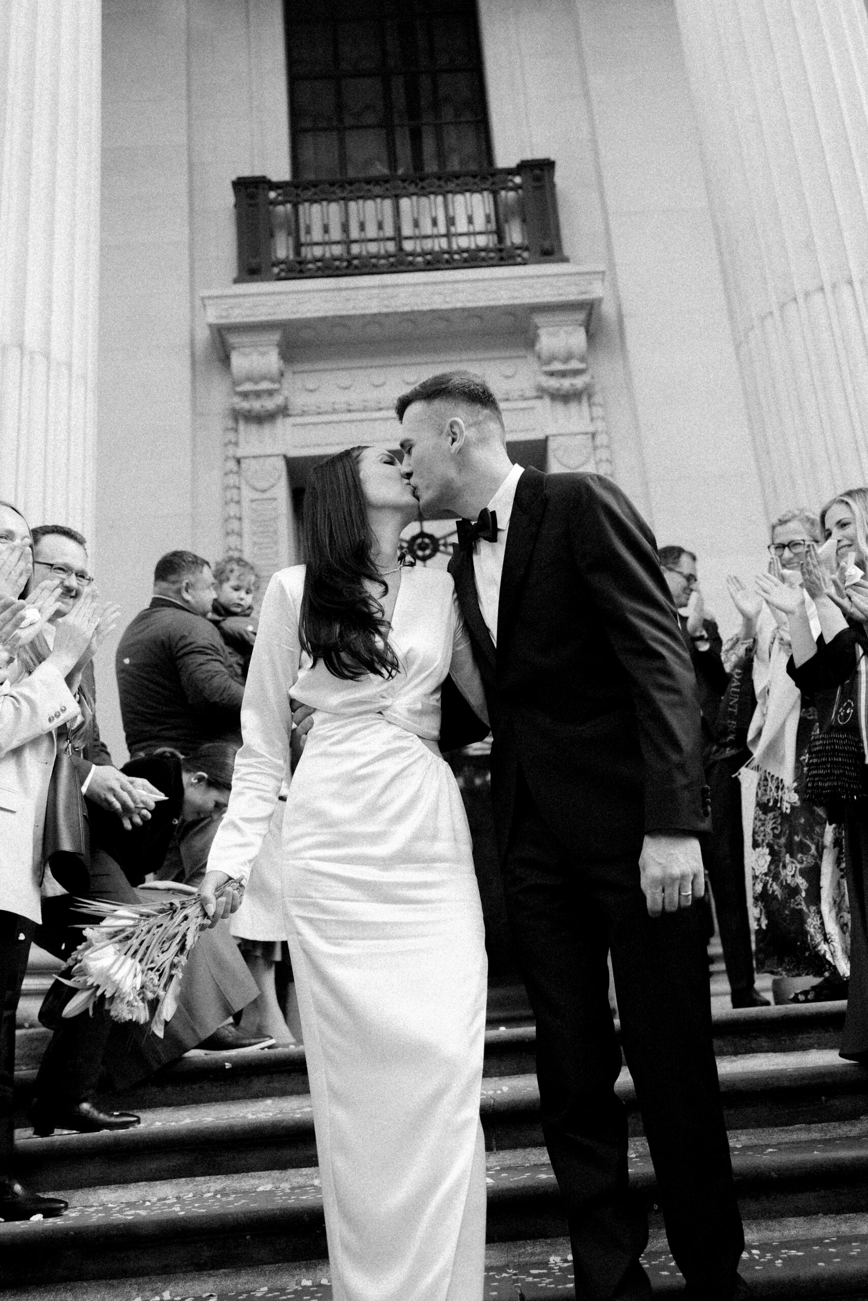 Newlyweds kiss on the steps of Old Marylebone Town Hall after their ceremony